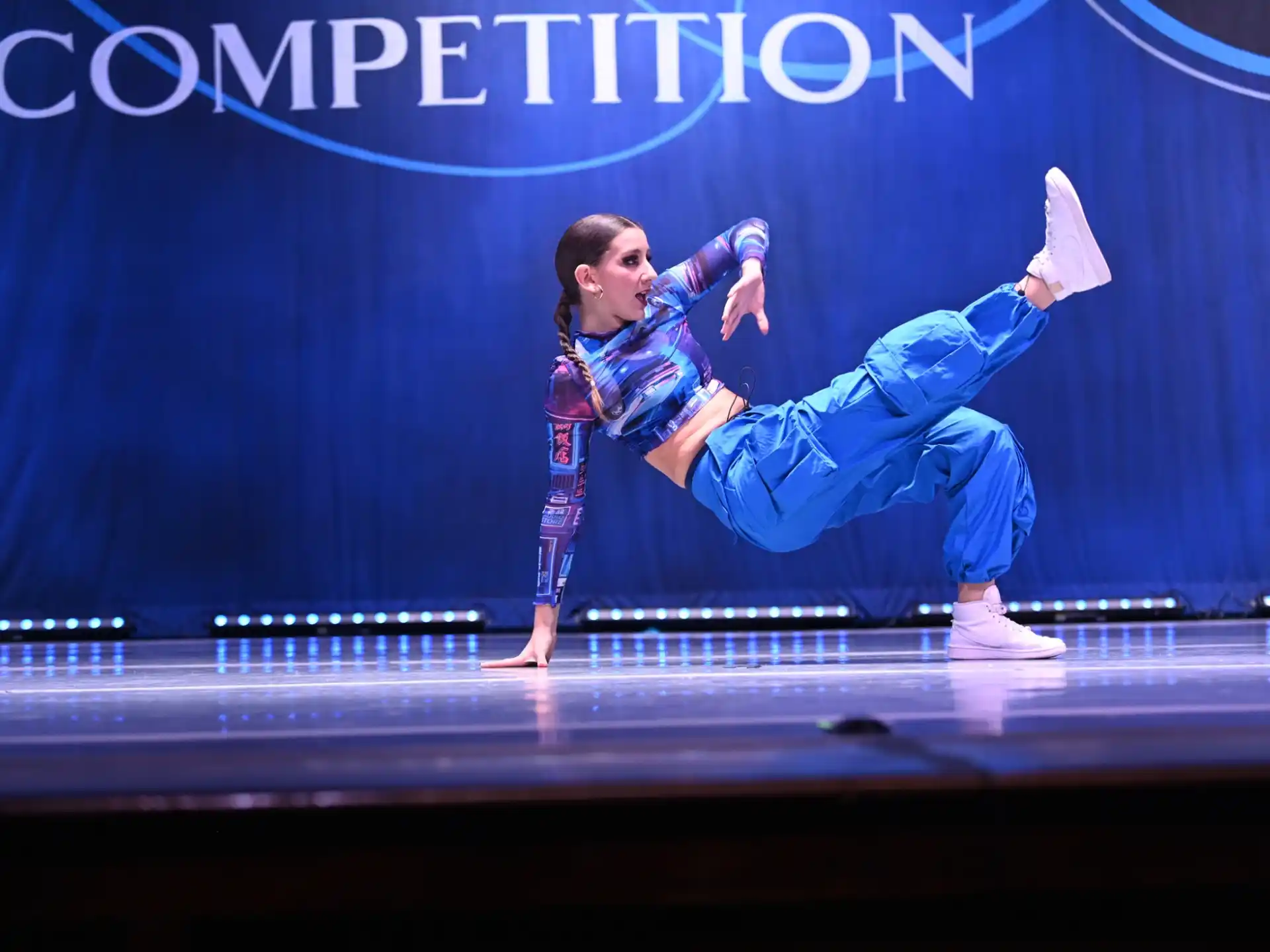 a man in blue suit dancing on a stage