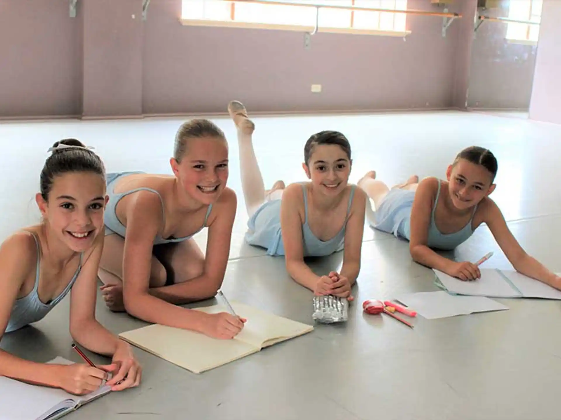 a group of women sitting on the floor and smiling