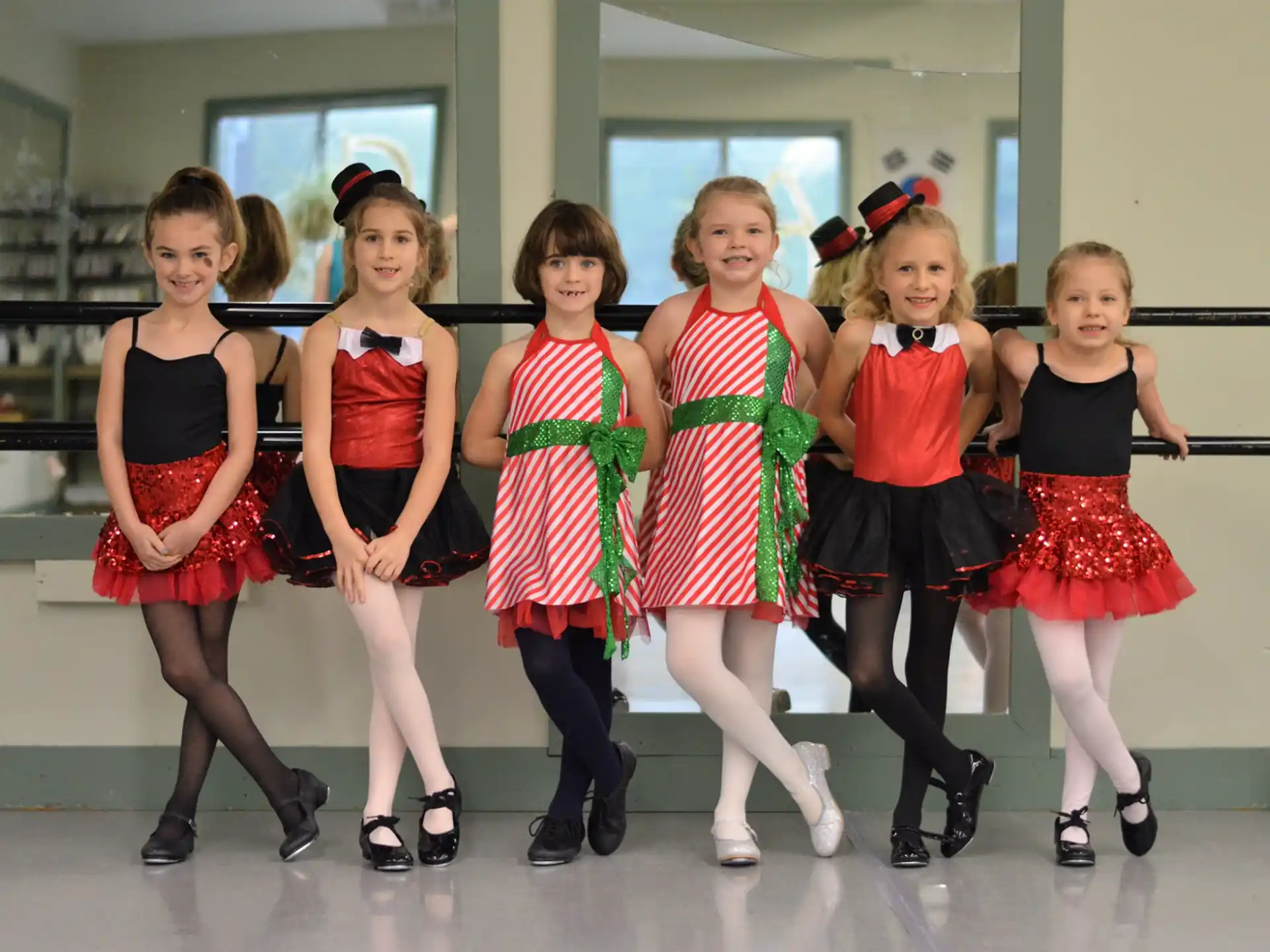 a group of girls in red and black dresses posing for a photo