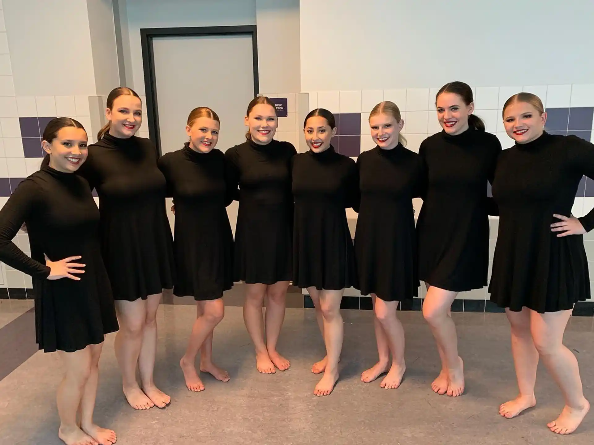 a group of women in black dresses