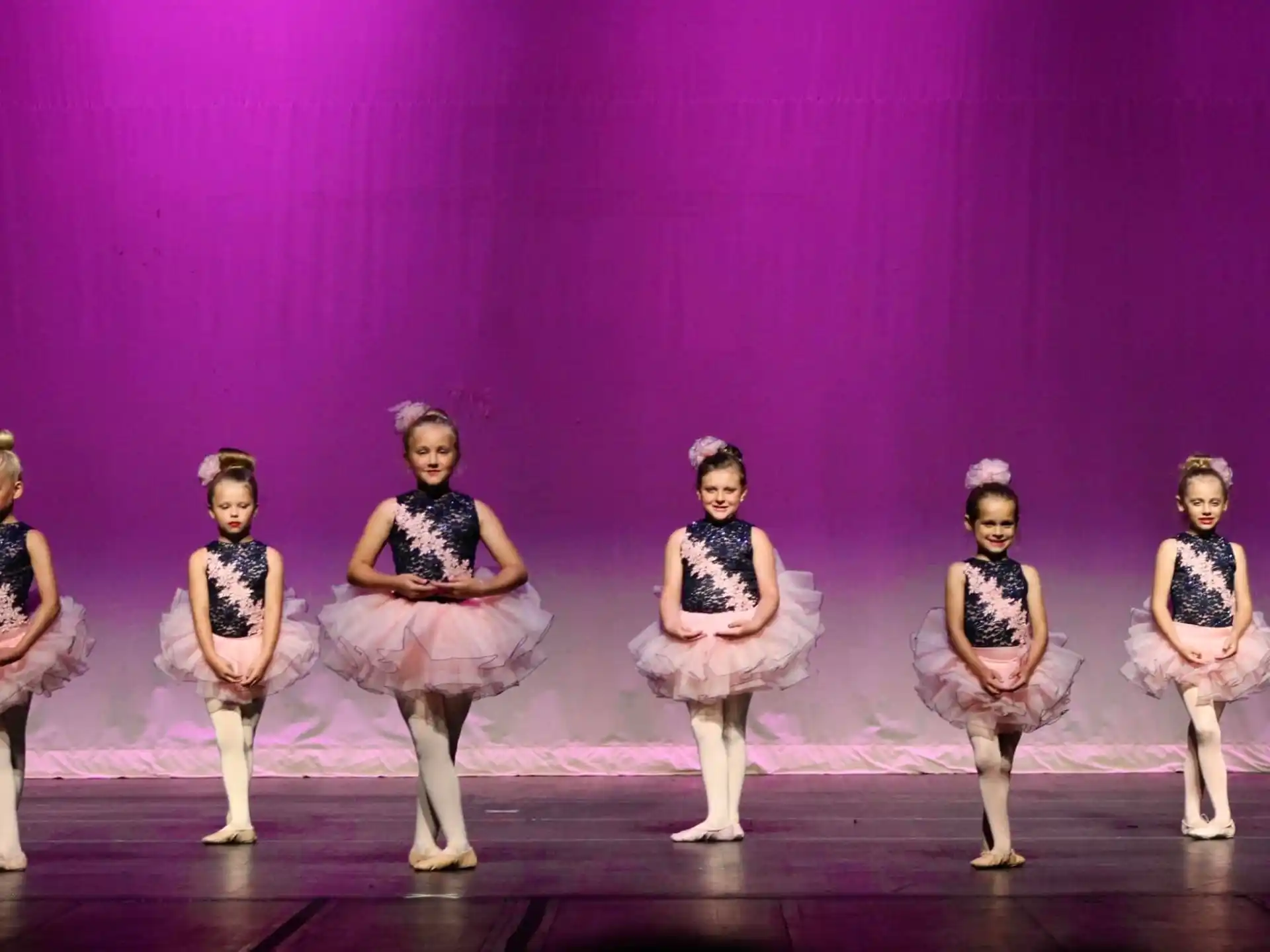 a group of women in dresses on a stage
