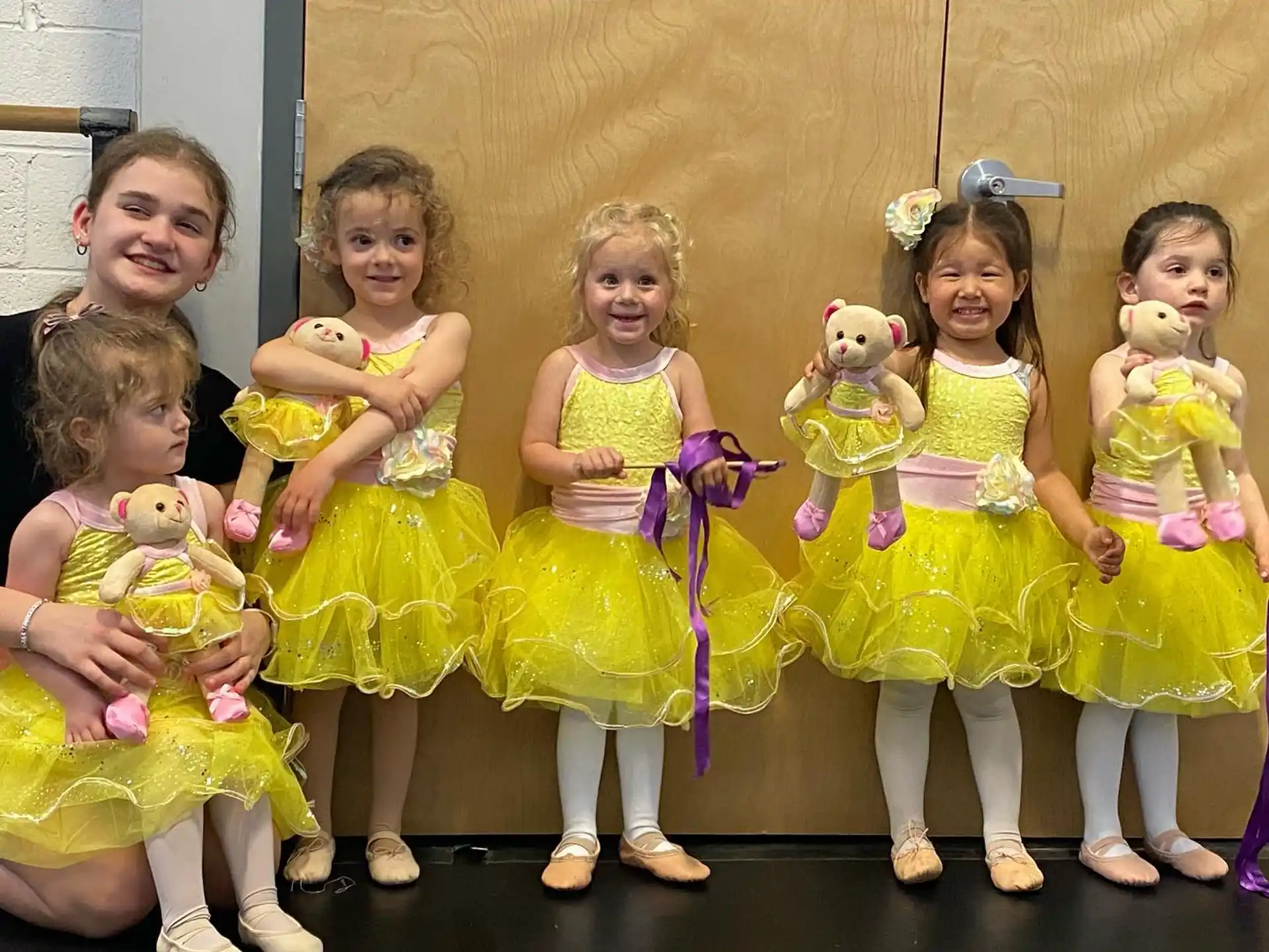 a group of children in yellow dresses