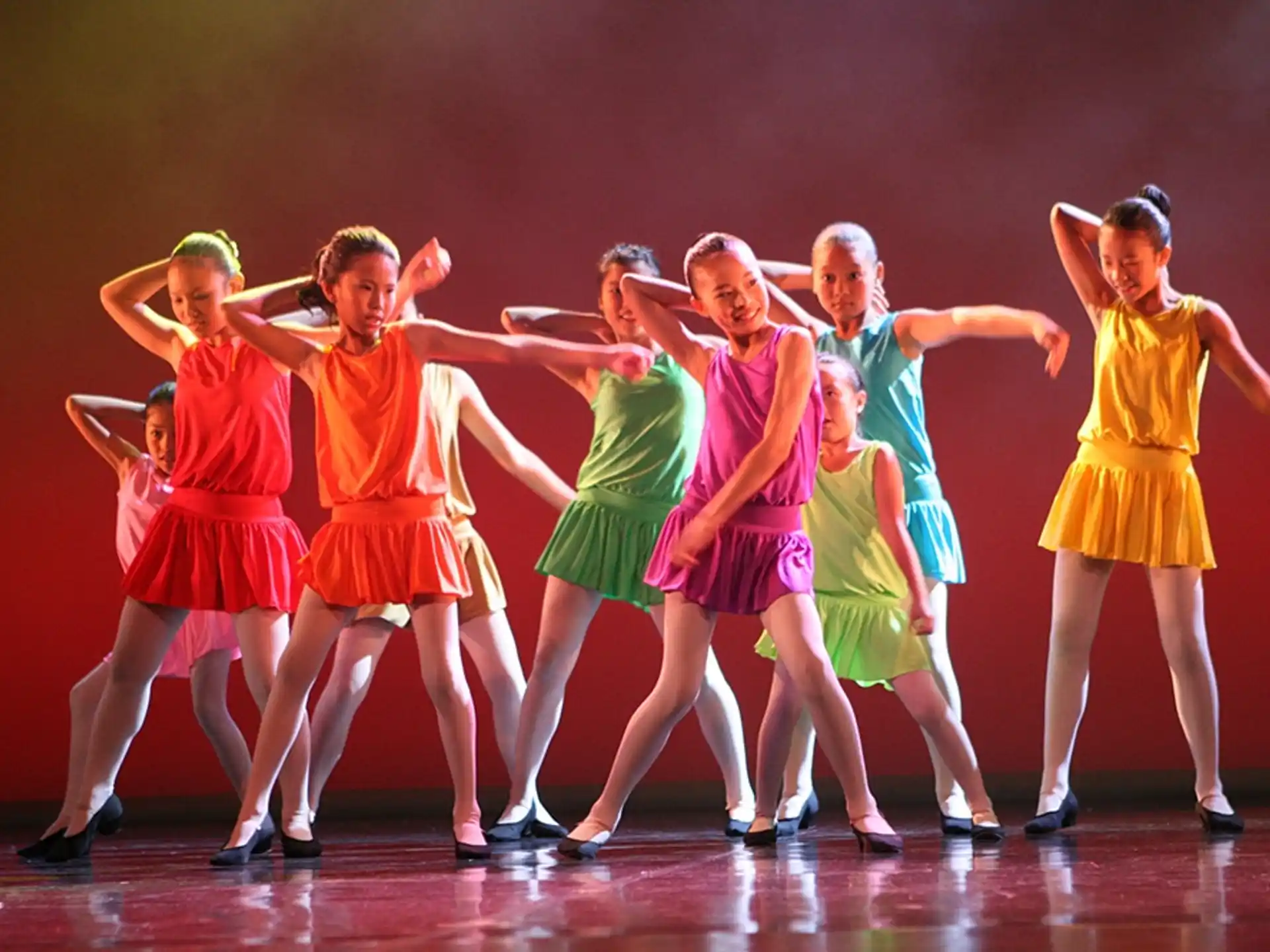 a group of girls dancing on a stage
