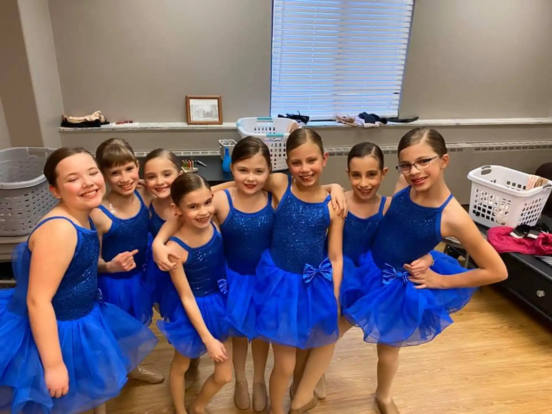 a group of girls in blue dresses