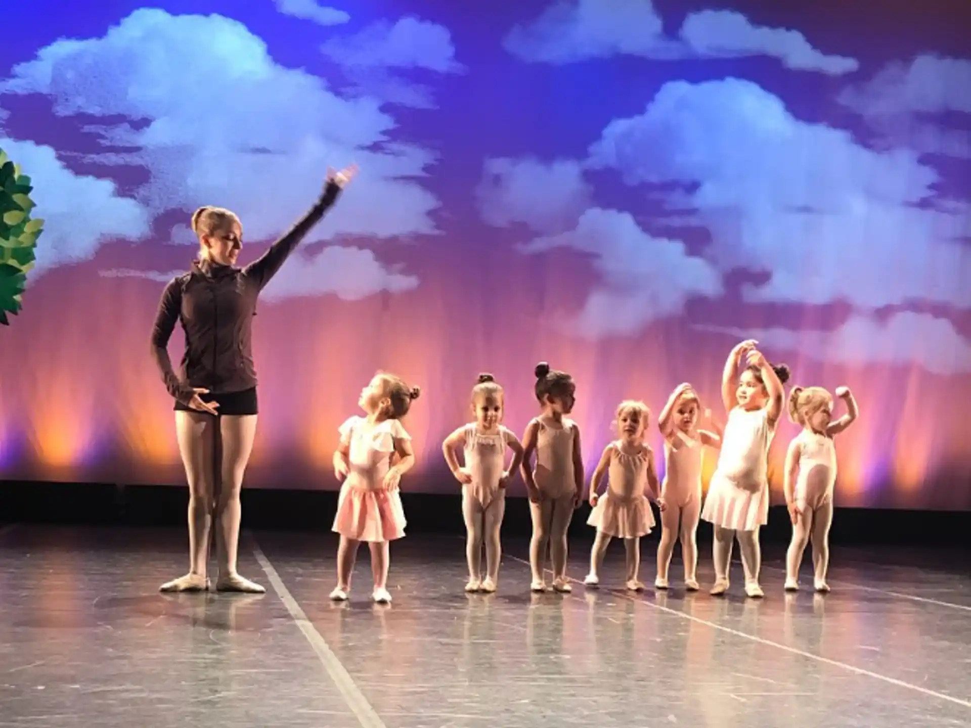 a person standing in front of a group of girls on a stage