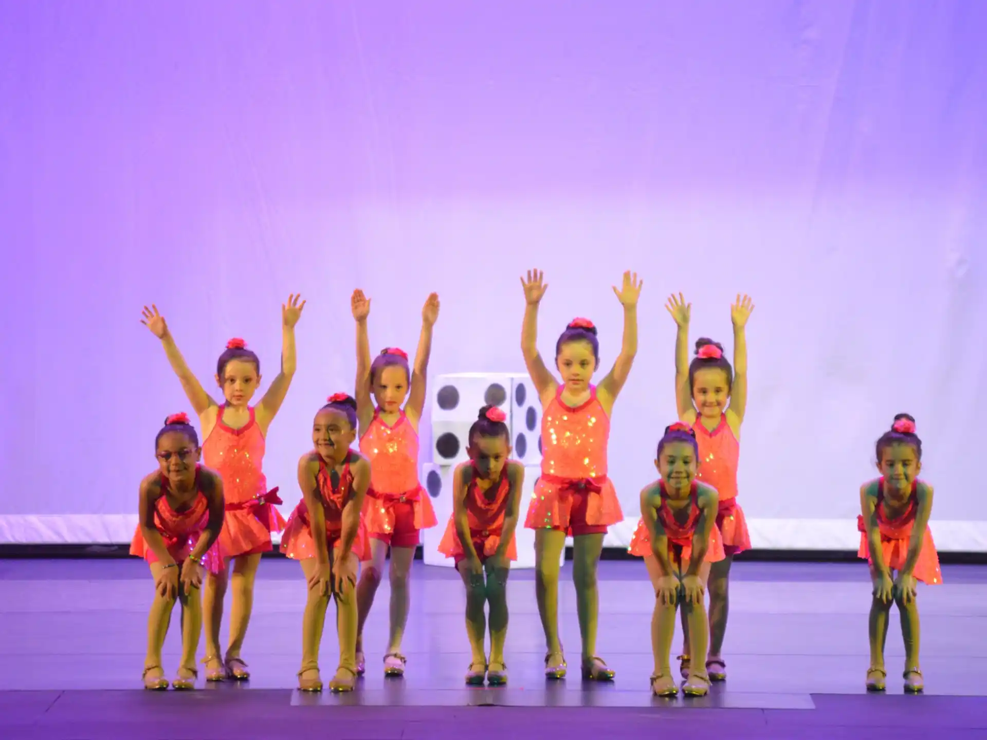 a group of girls in red and gold uniforms on a stage