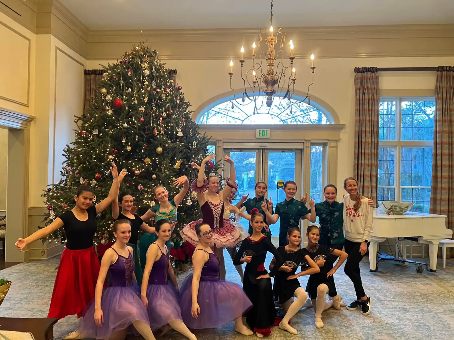 a group of people posing for a photo in front of a christmas tree