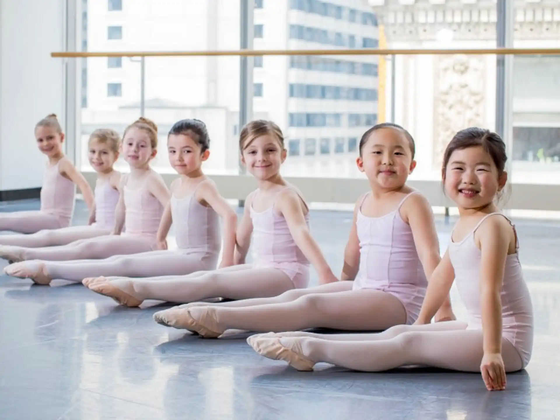 a group of girls sitting on the floor in front of a window