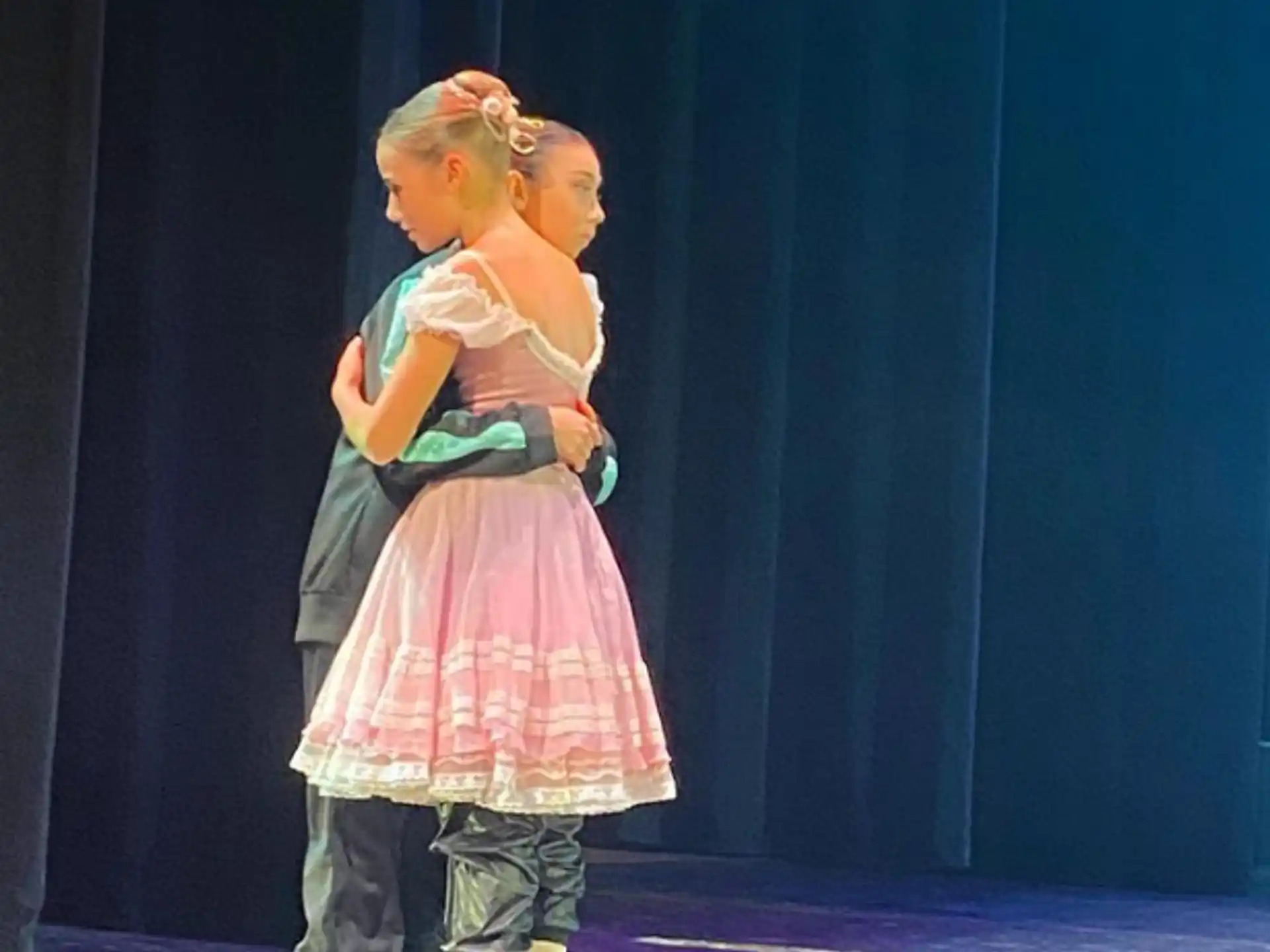 two girls in dresses hugging