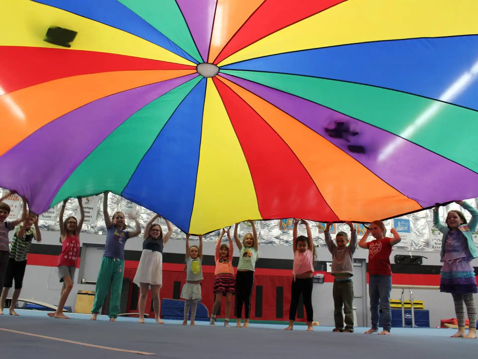 a group of people standing under a colorful umbrella