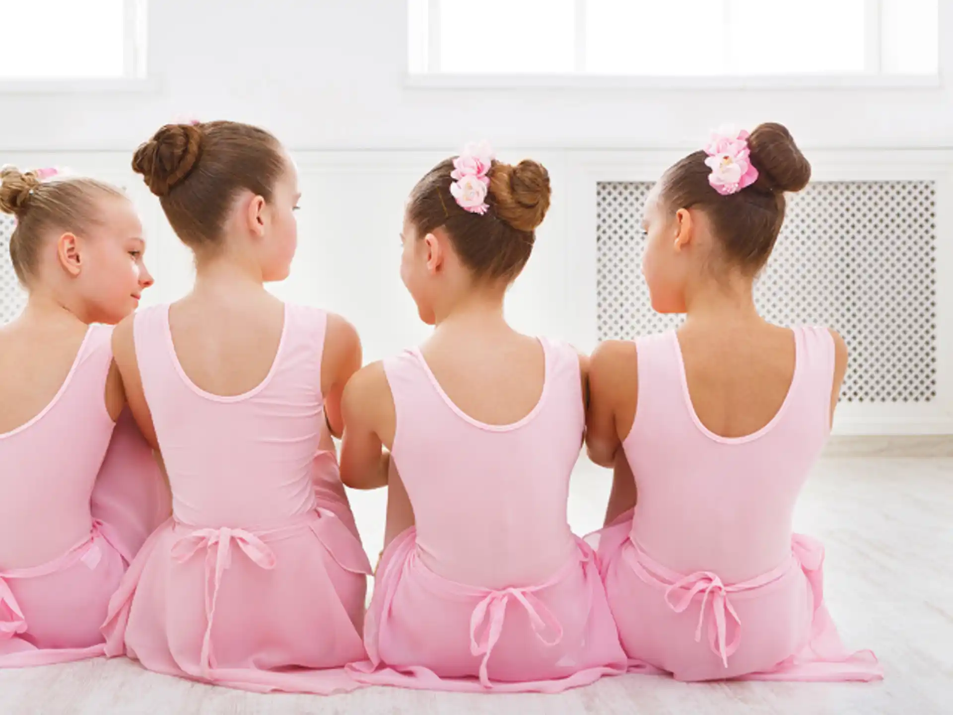 a group of girls in pink dresses