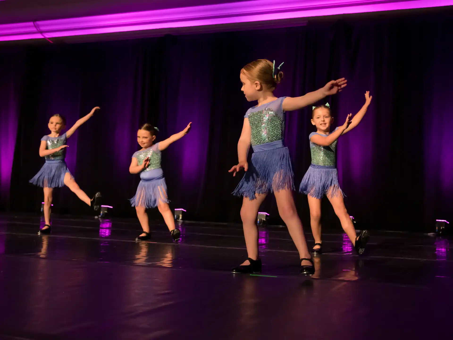 a group of girls dancing on a stage