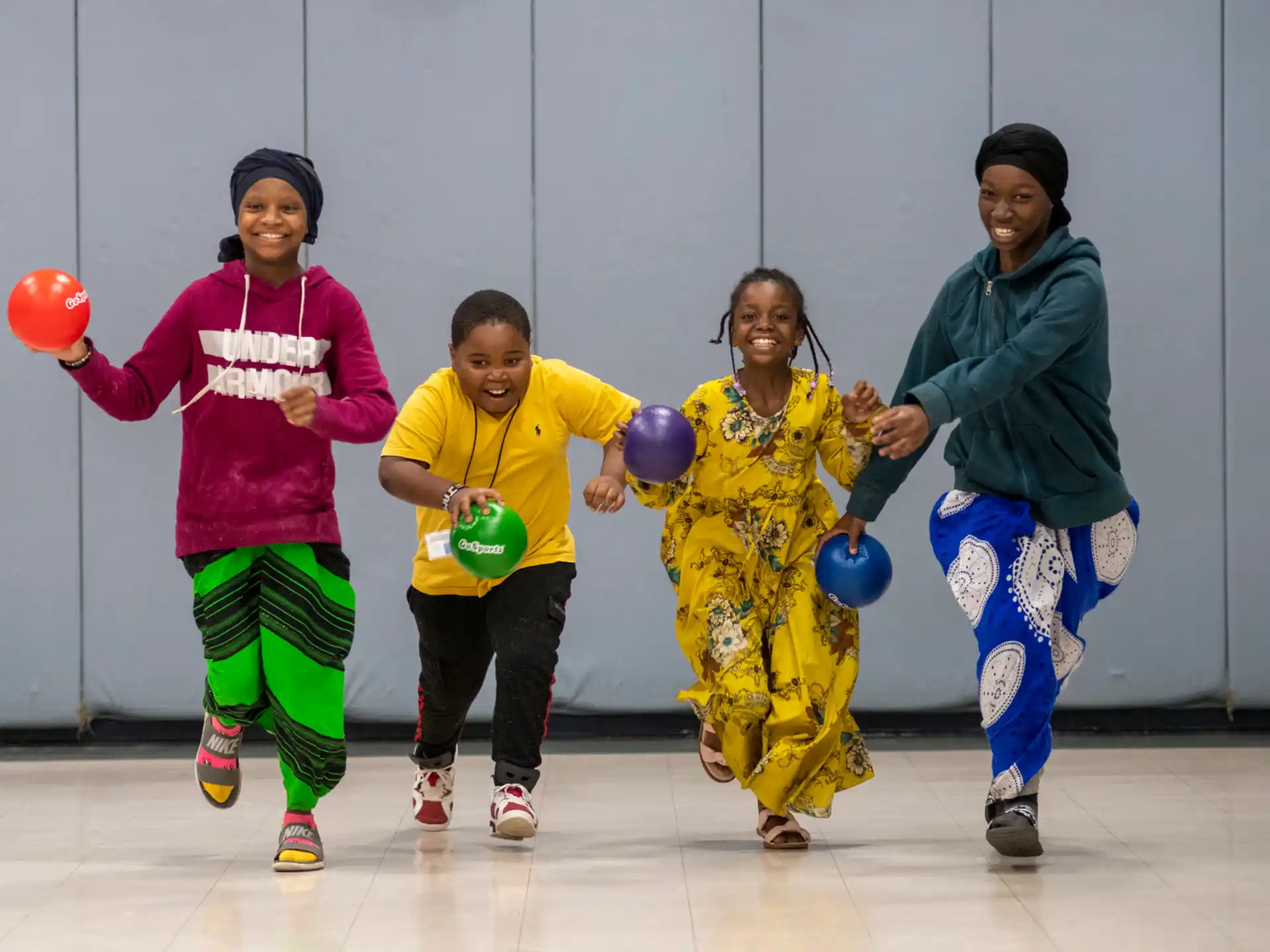 a group of kids holding balls