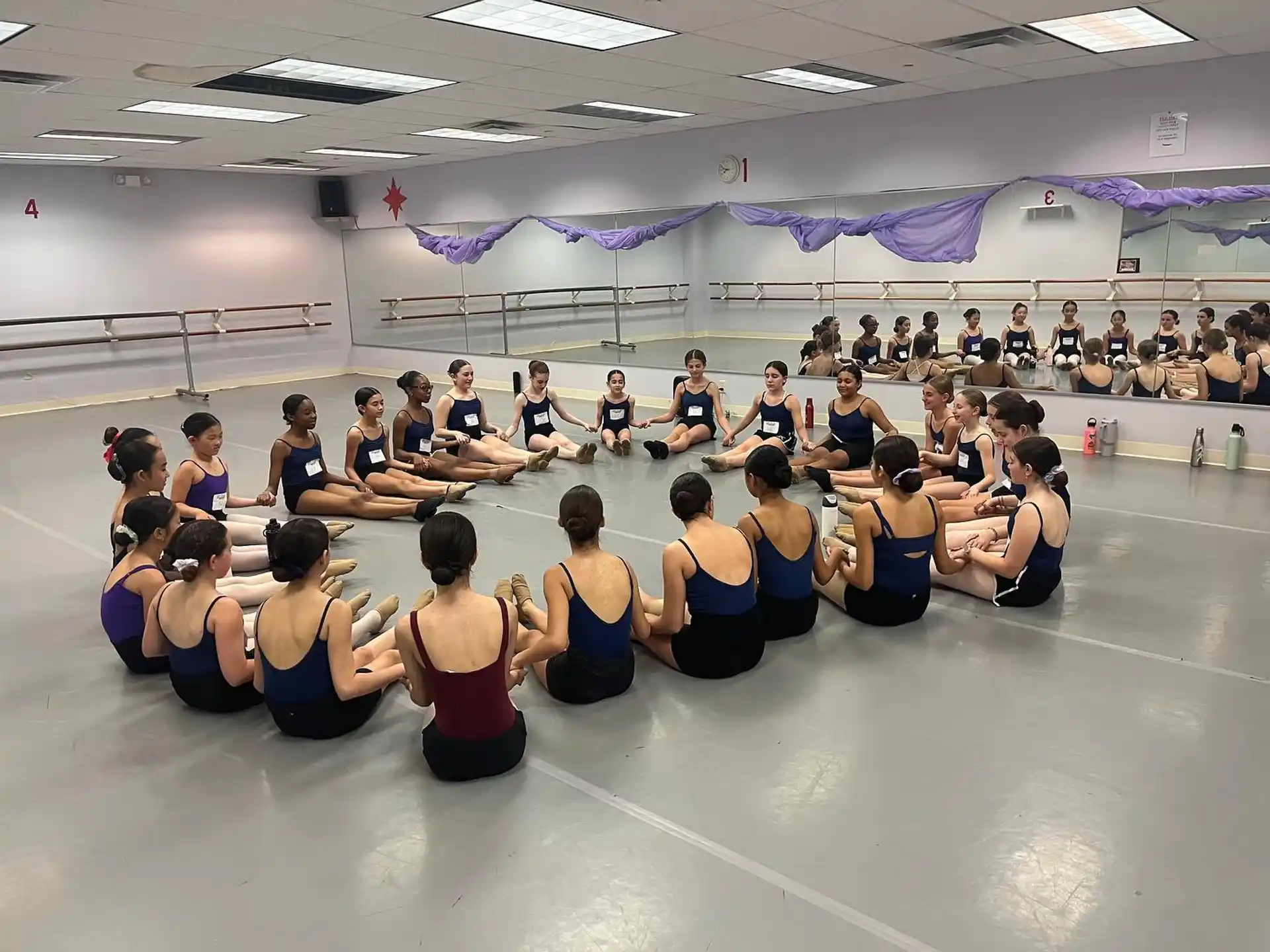 a group of people sitting on a floor in a room