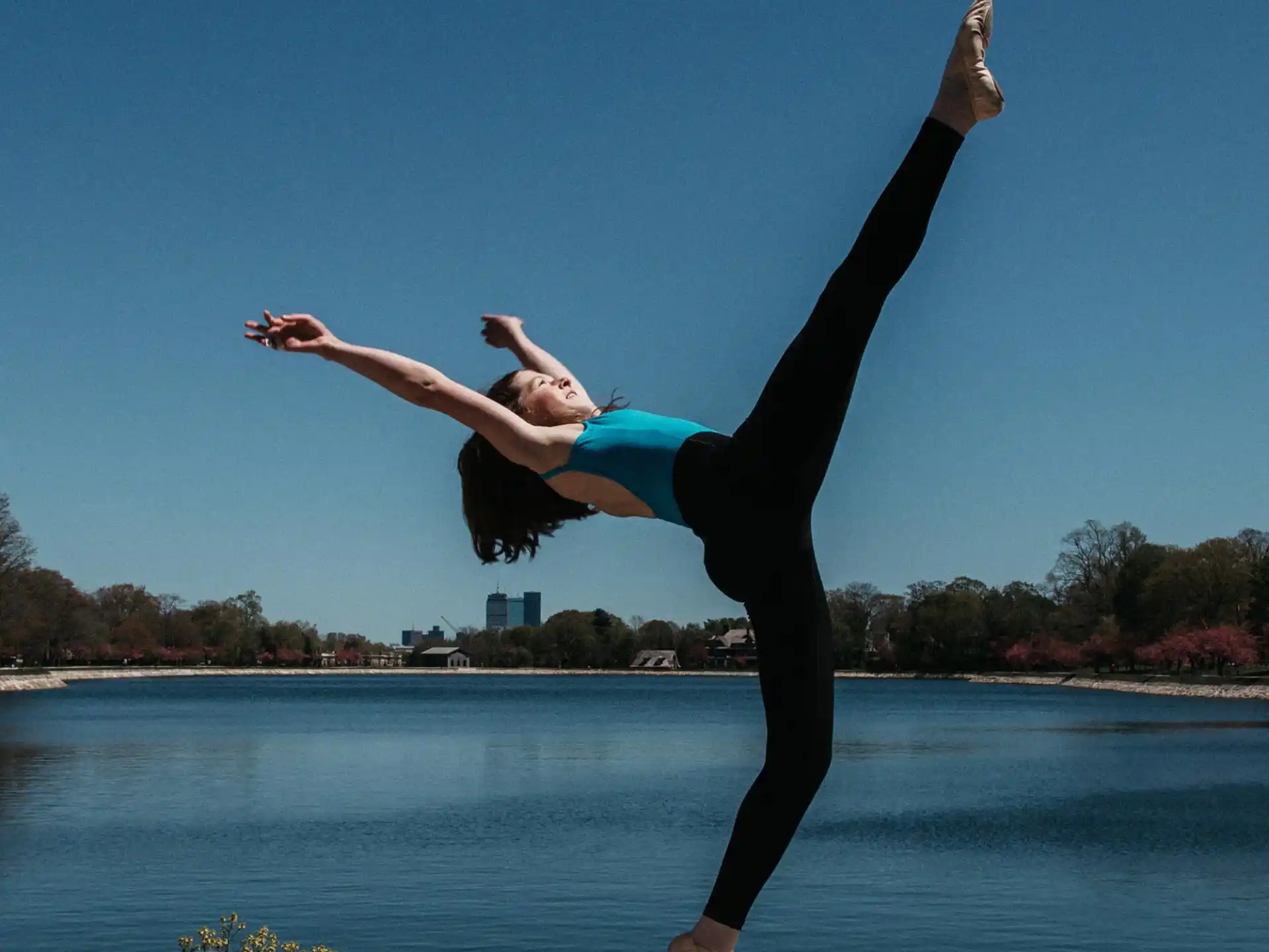 a person doing a handstand by a body of water