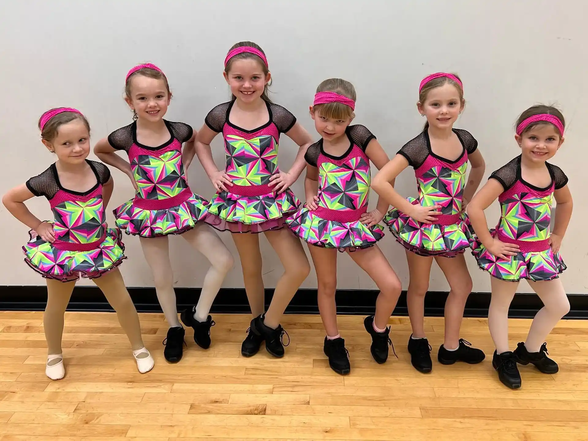 a group of girls in colorful dresses