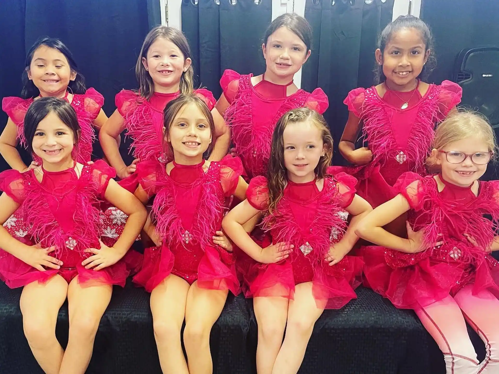 a group of girls in red dresses