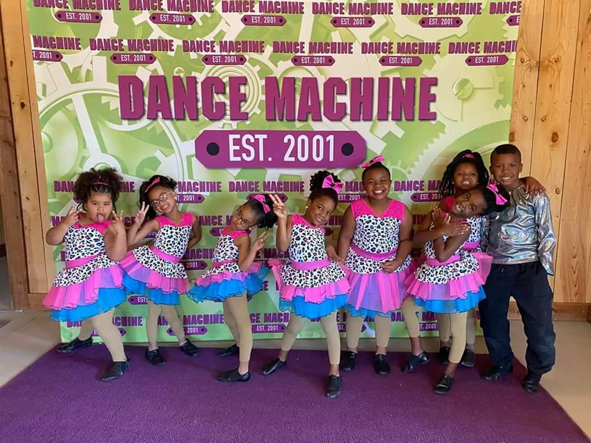 a group of girls posing for a photo in front of a sign