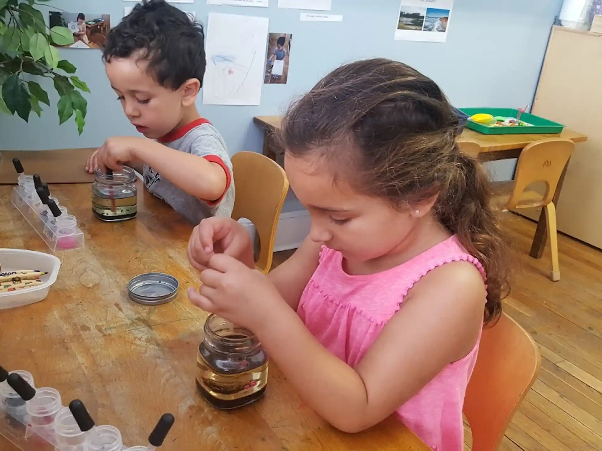 a couple of children sitting at a table eating food