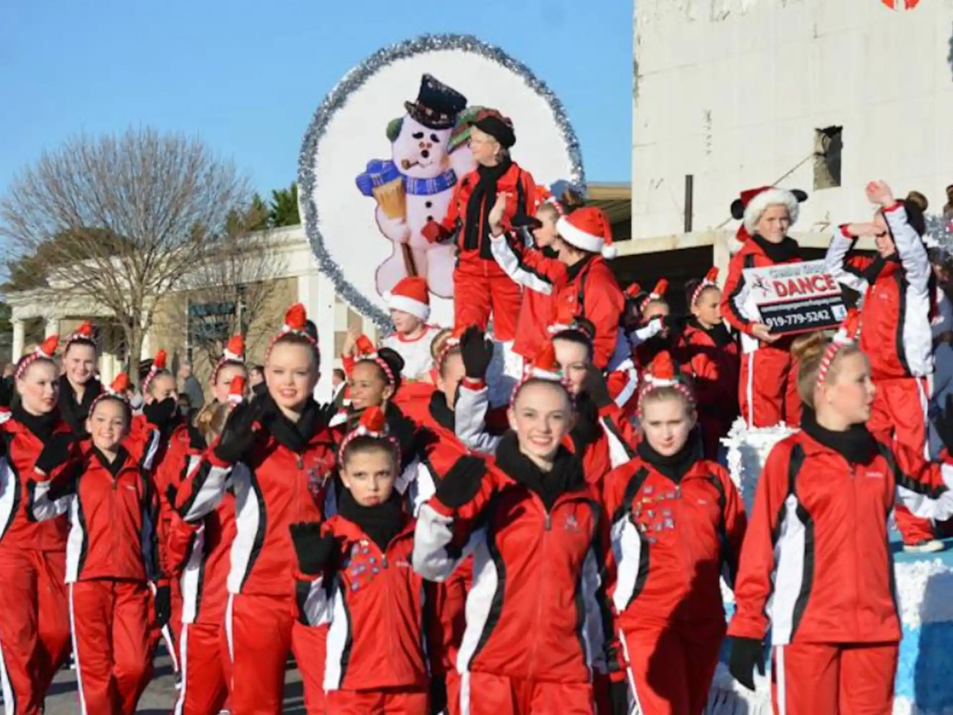 a group of people in red and white uniforms holding a sign