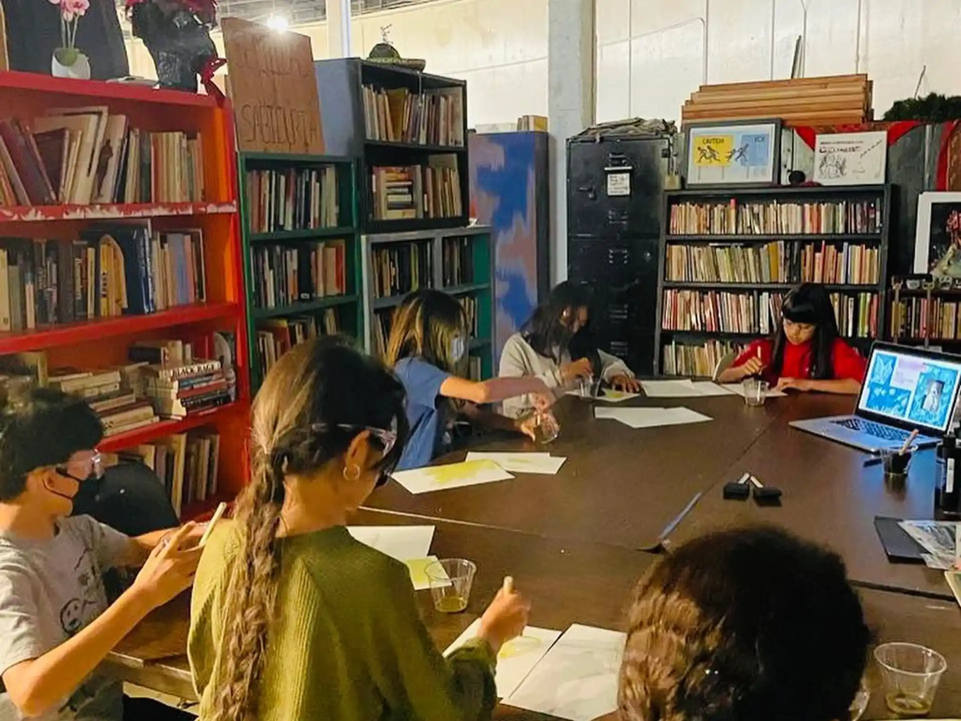 a group of people sitting at a table in a library