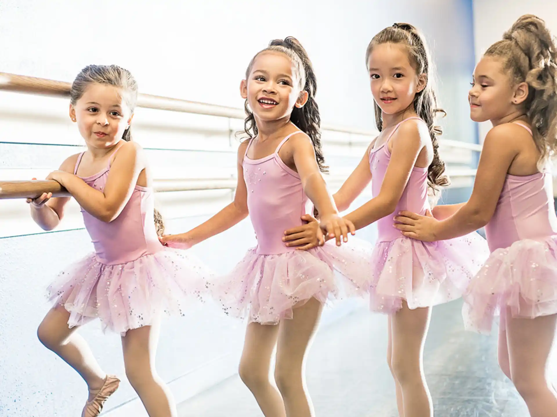 a group of girls in pink dresses