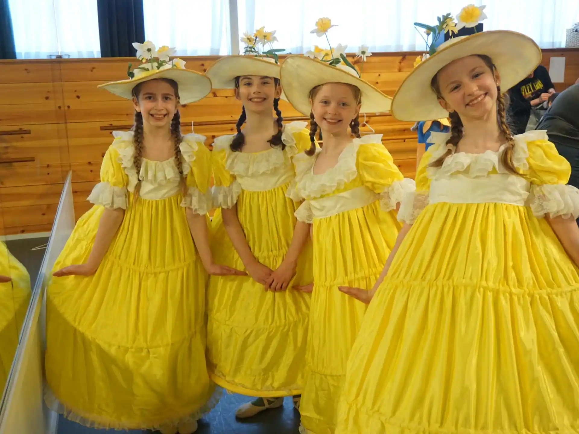 a group of women in yellow dresses