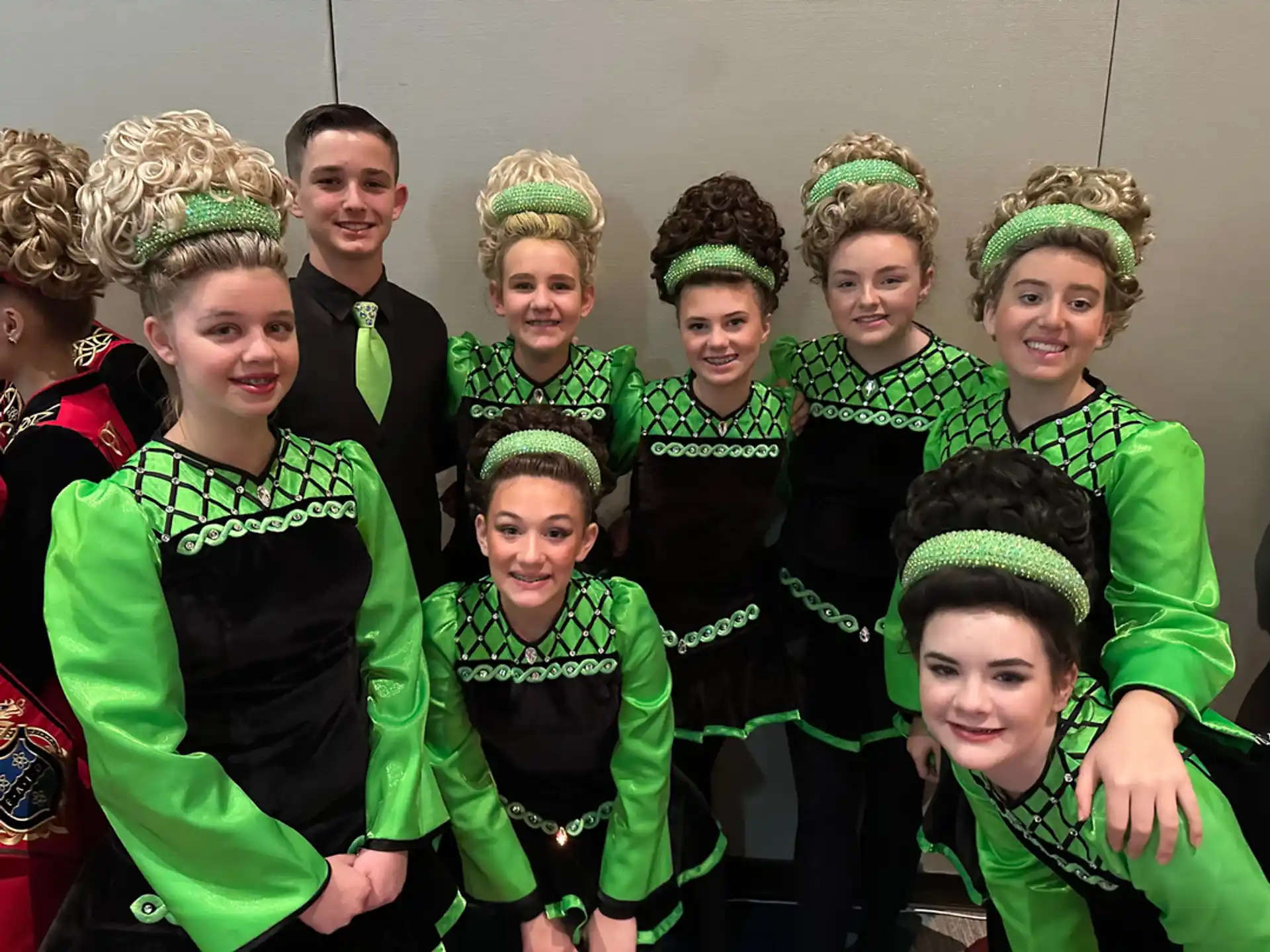 a group of people wearing green and black clothing