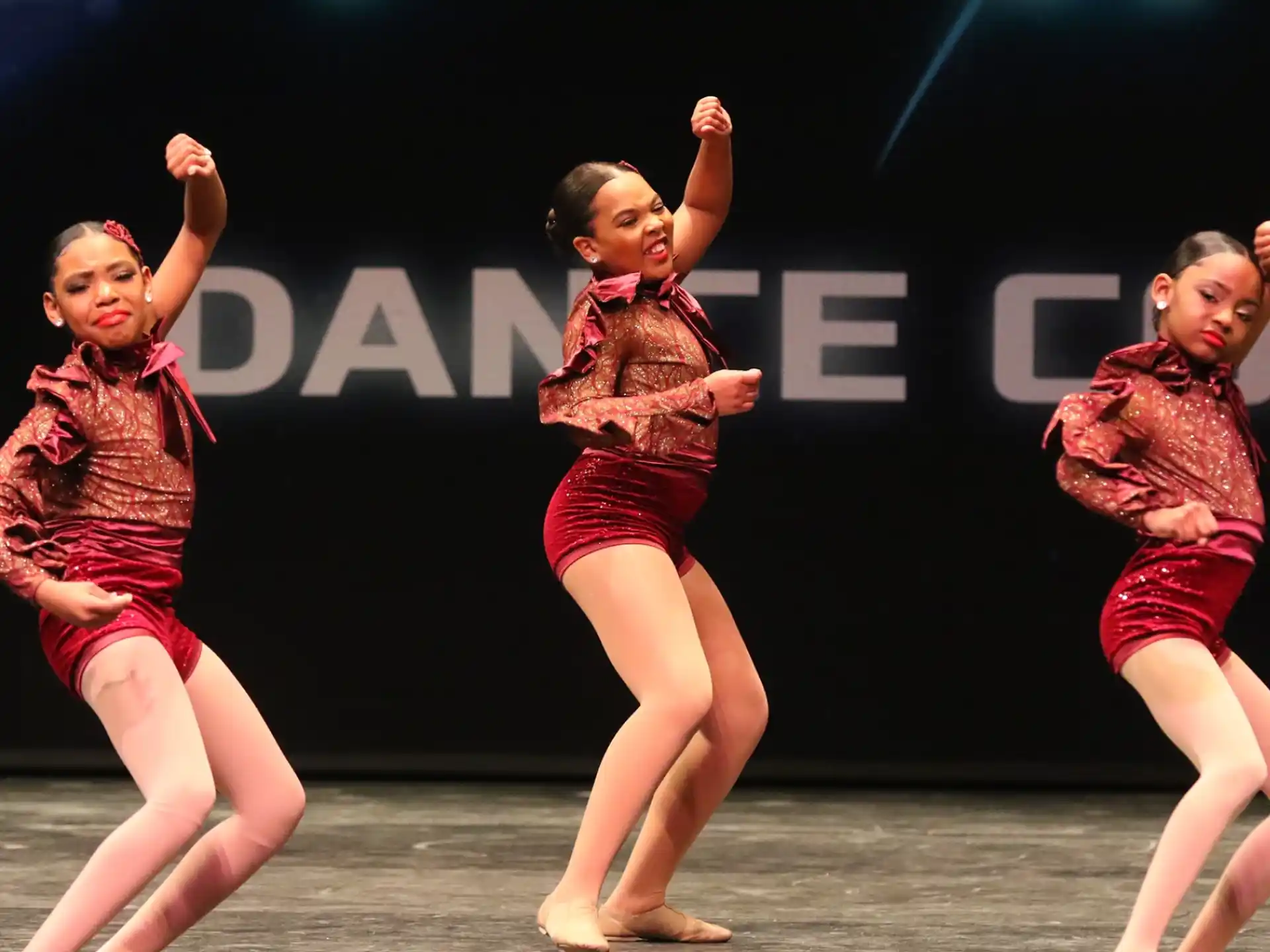 a group of girls dancing on a stage