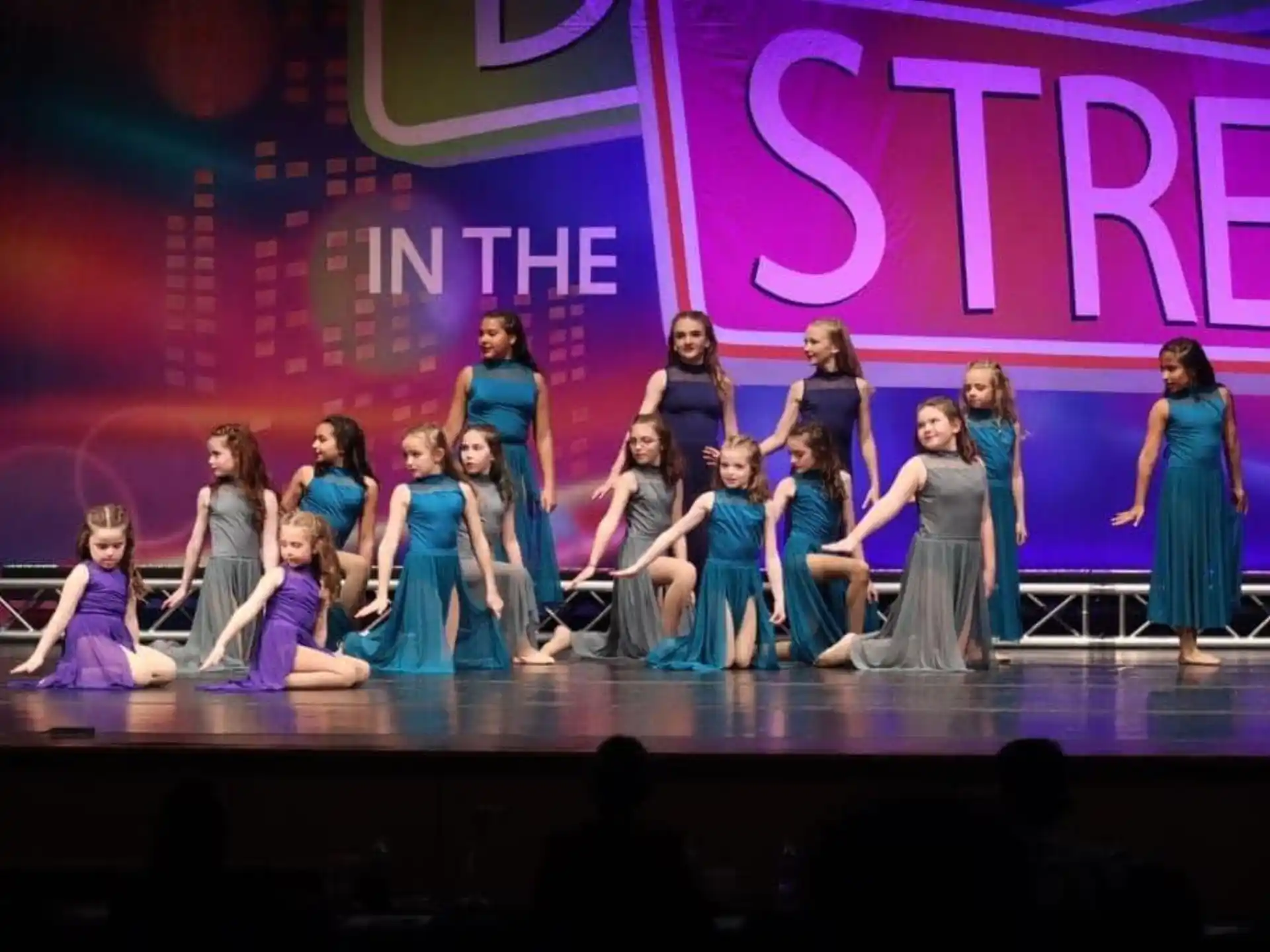 a group of women in dresses on a stage