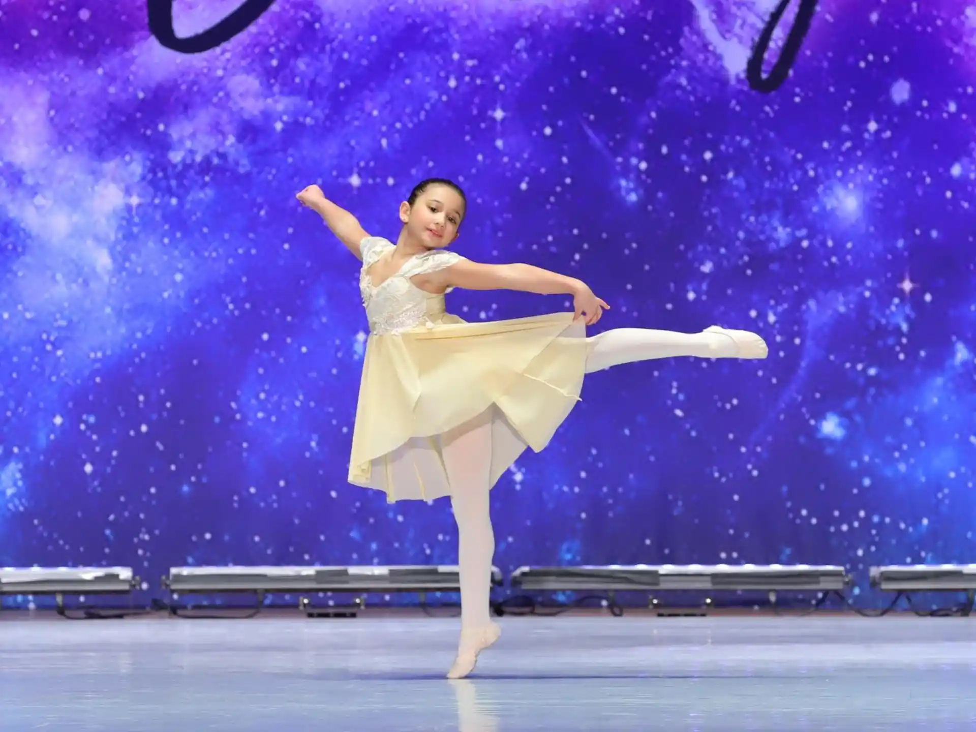 a person in a white dress dancing on a stage