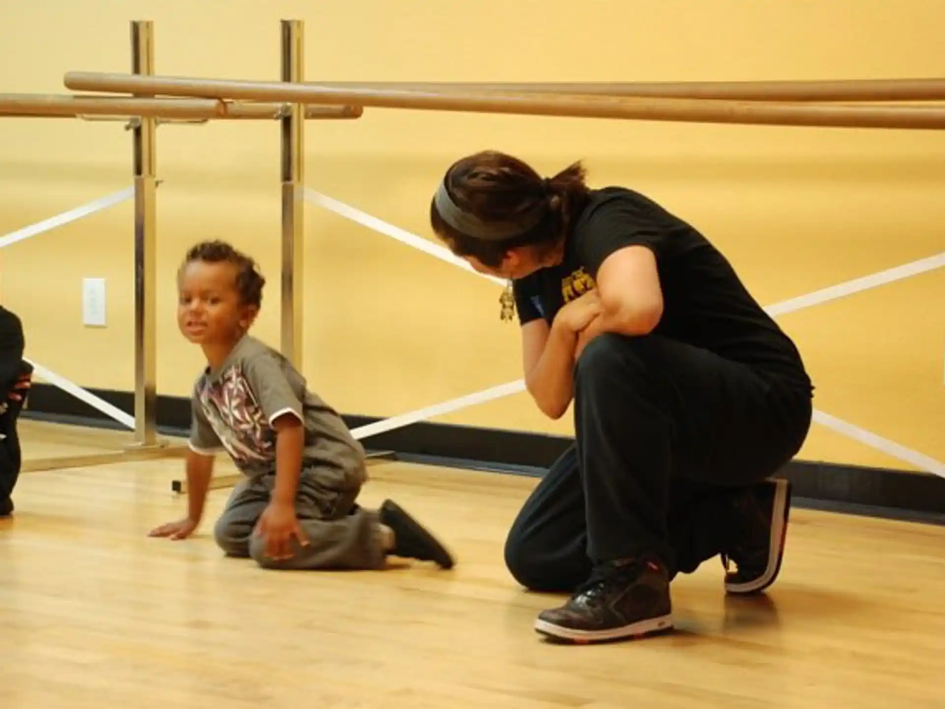 a person helping a boy do push ups