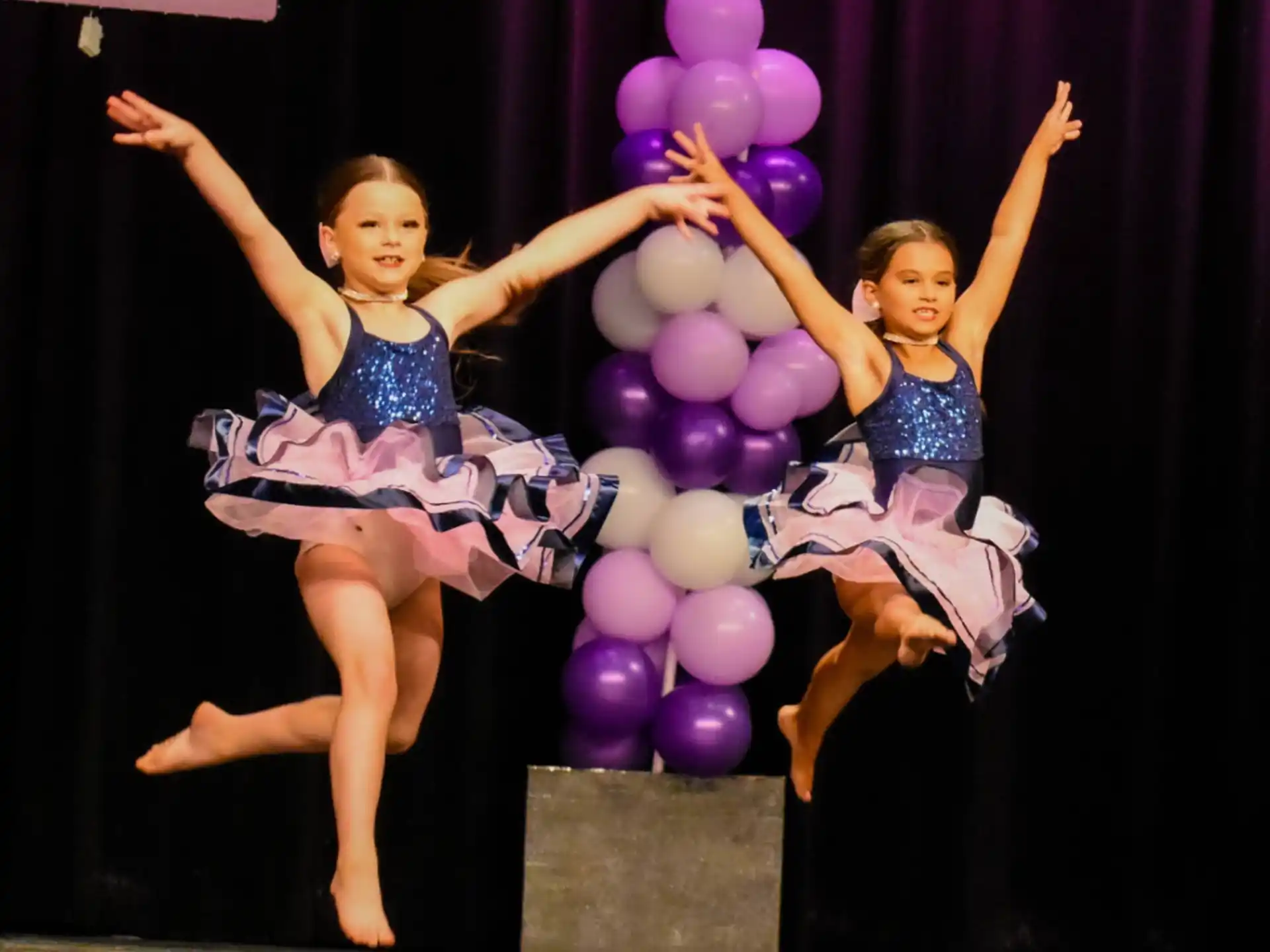 two women in dresses holding balloons