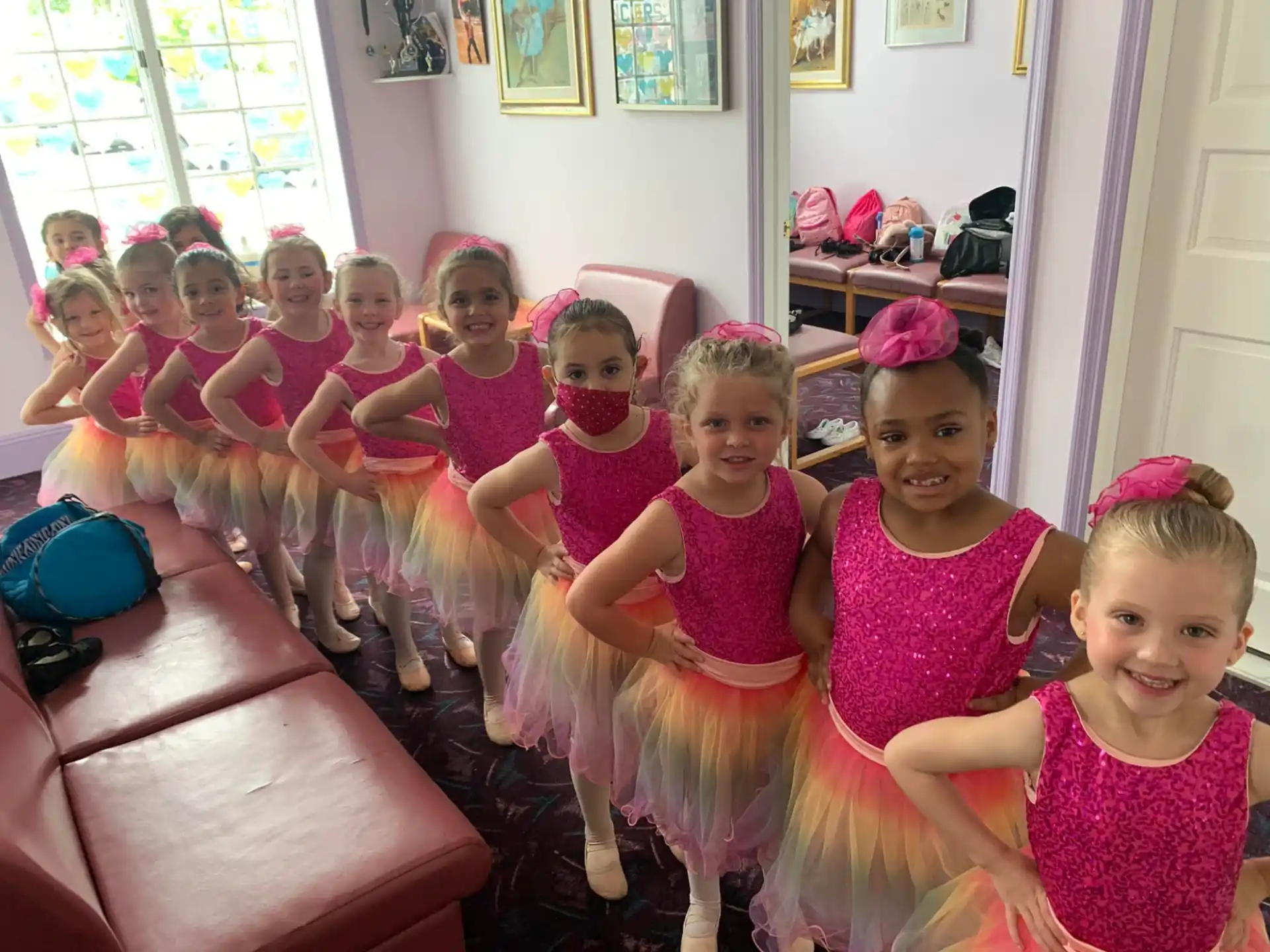 a group of girls in pink dresses