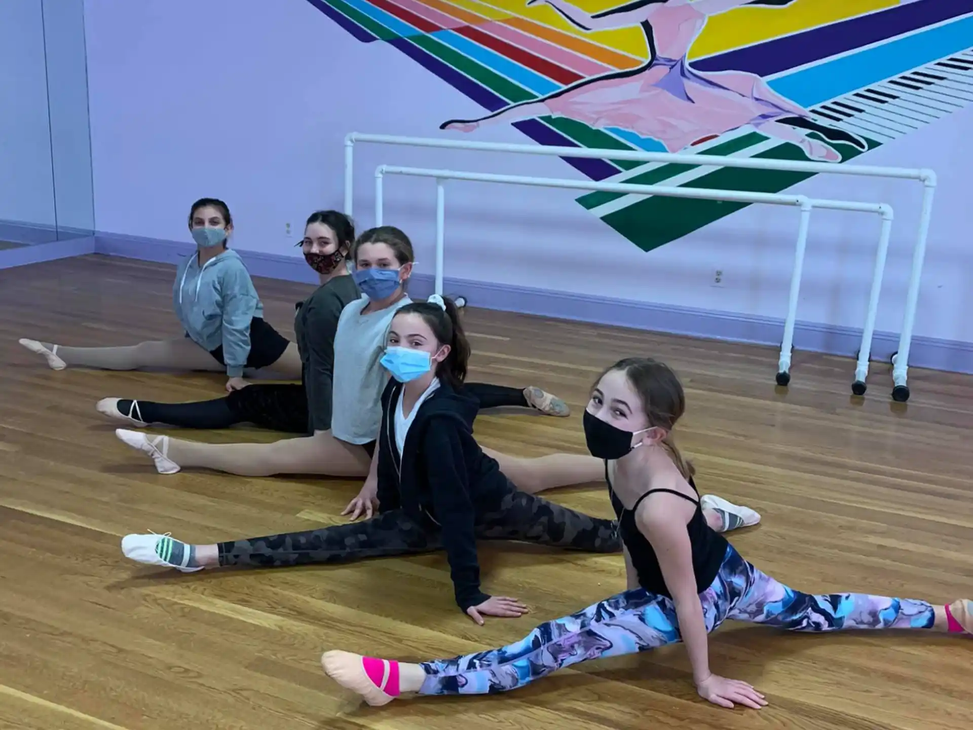 a group of people sitting on the floor in front of a colorful wall