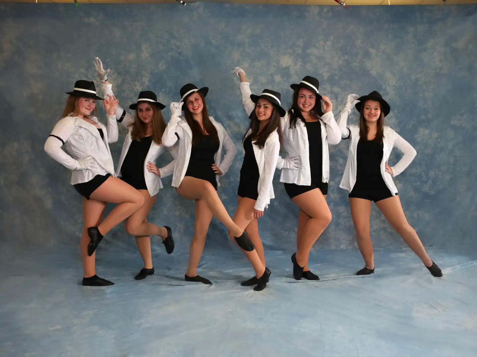 a group of women wearing hats and dancing on ice