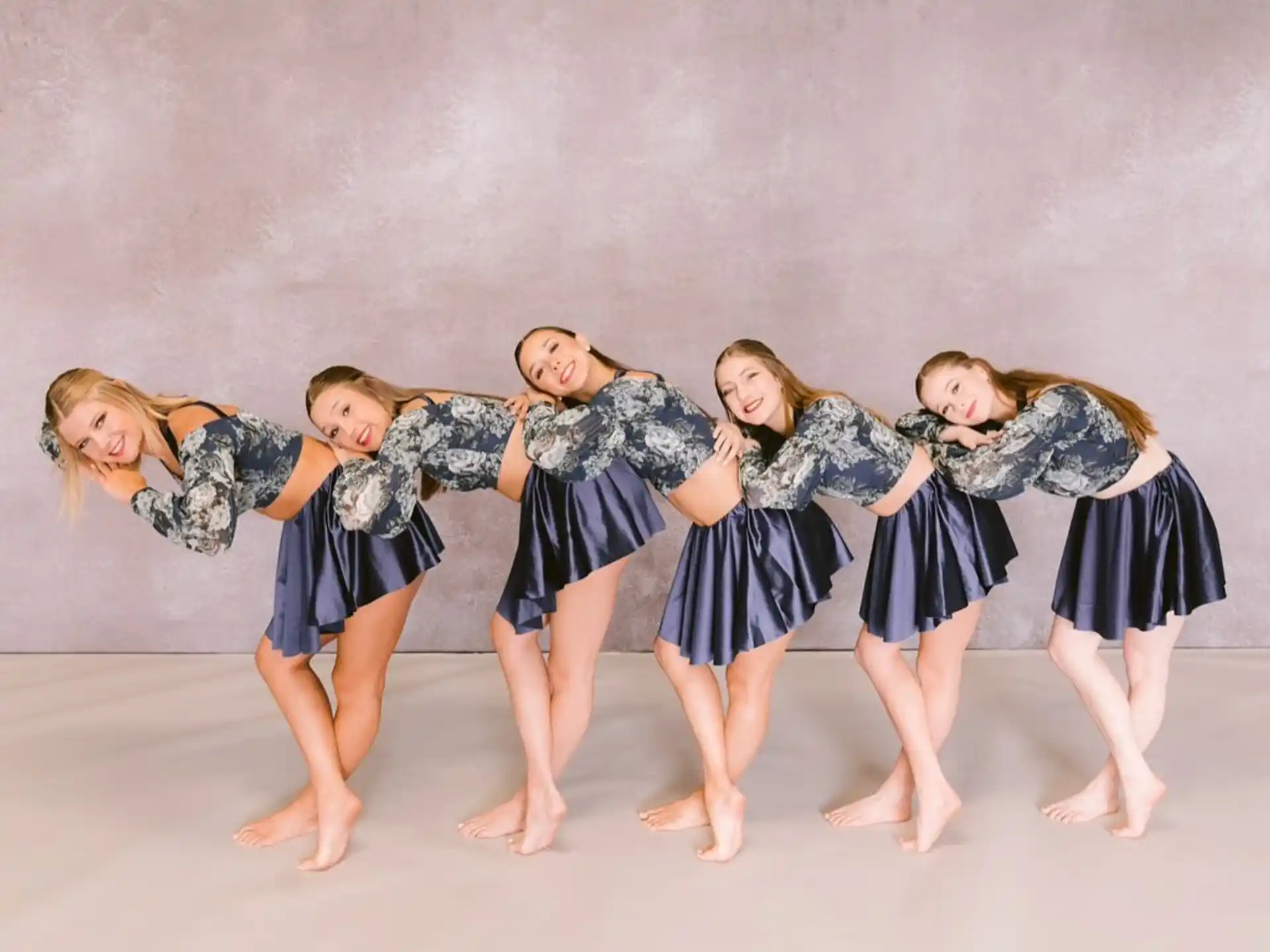 a group of girls in blue and white dresses dancing