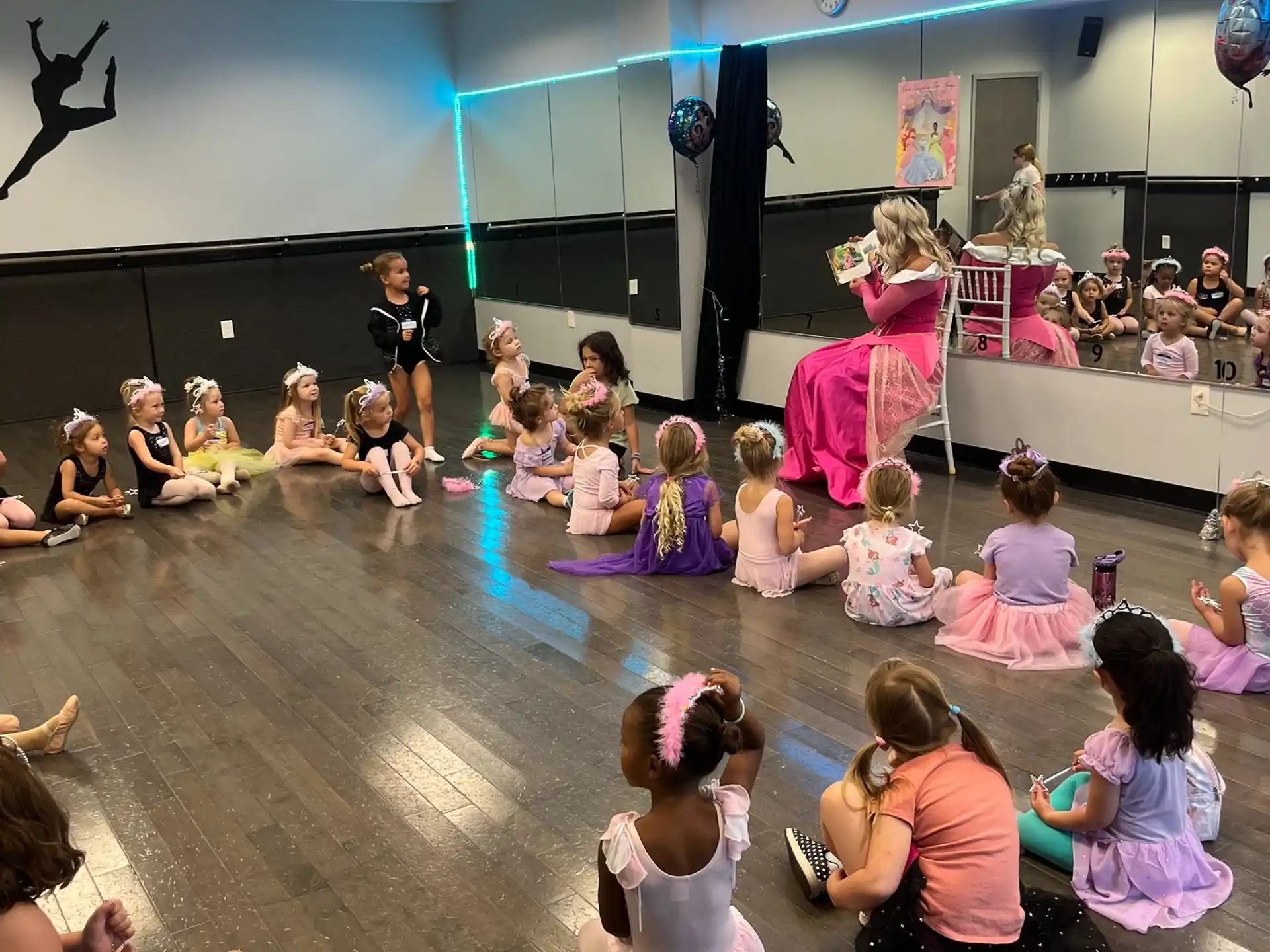 a group of children sitting on the floor in front of a stage