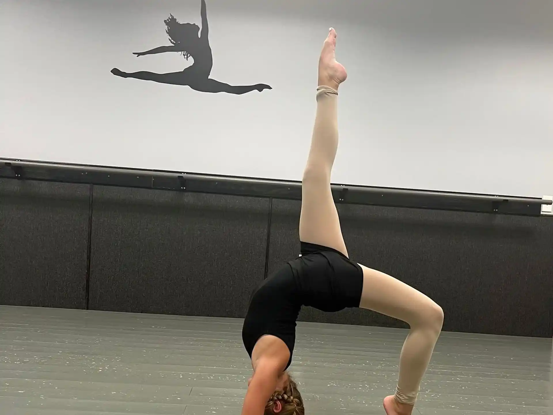 a woman doing a handstand on a floor with a star in the background