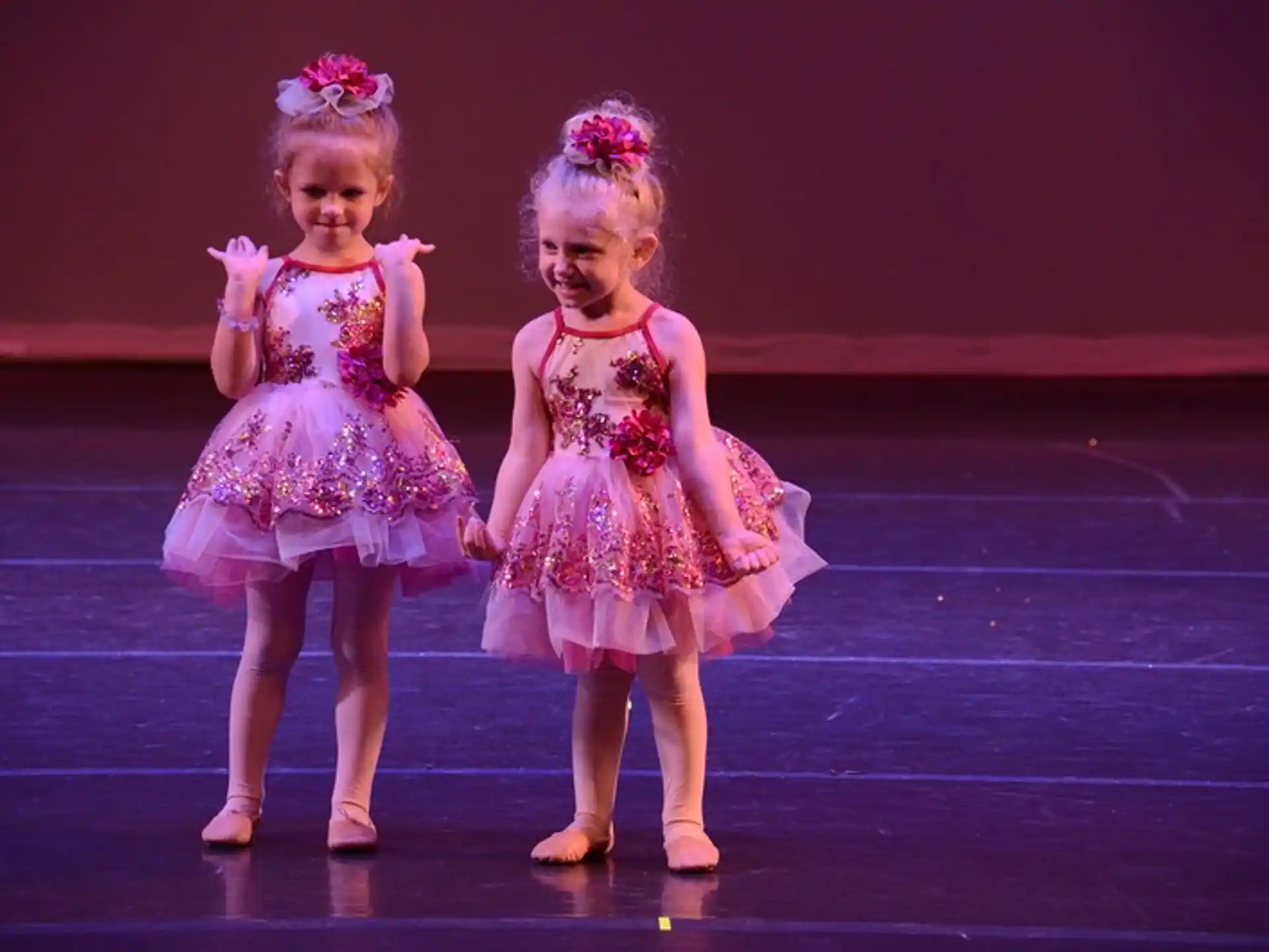 two girls wearing dresses and dancing