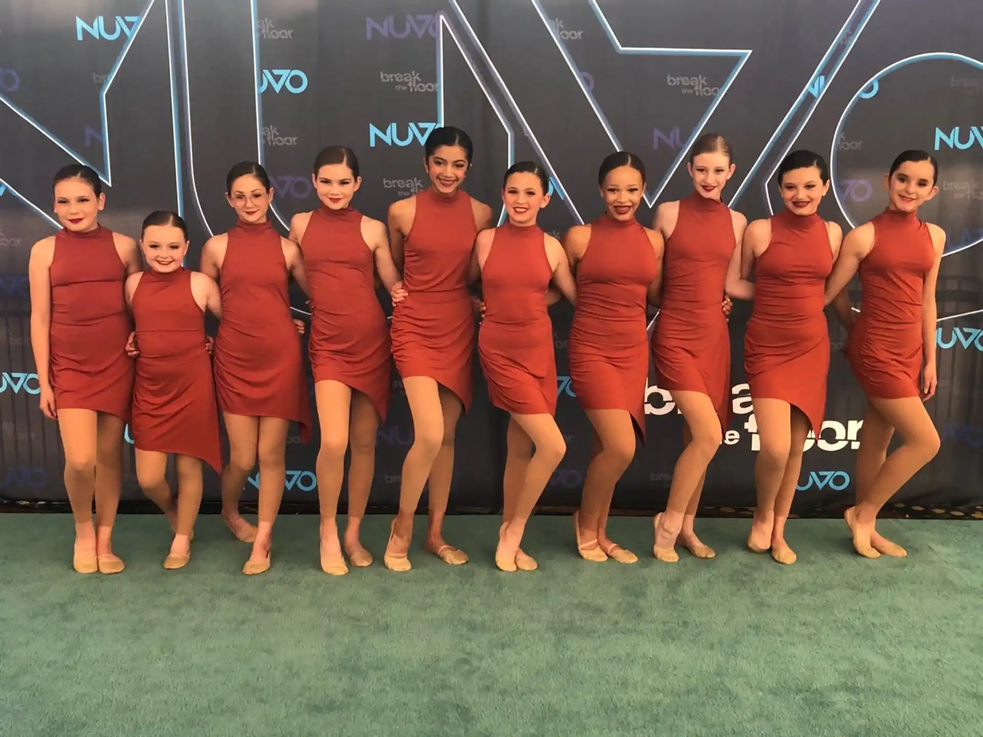 a group of women in red dresses