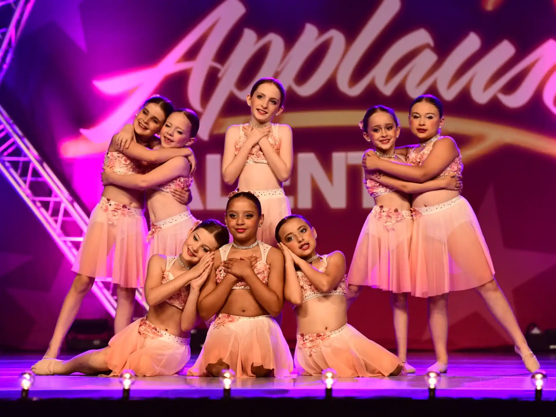 a group of women in dresses on a stage