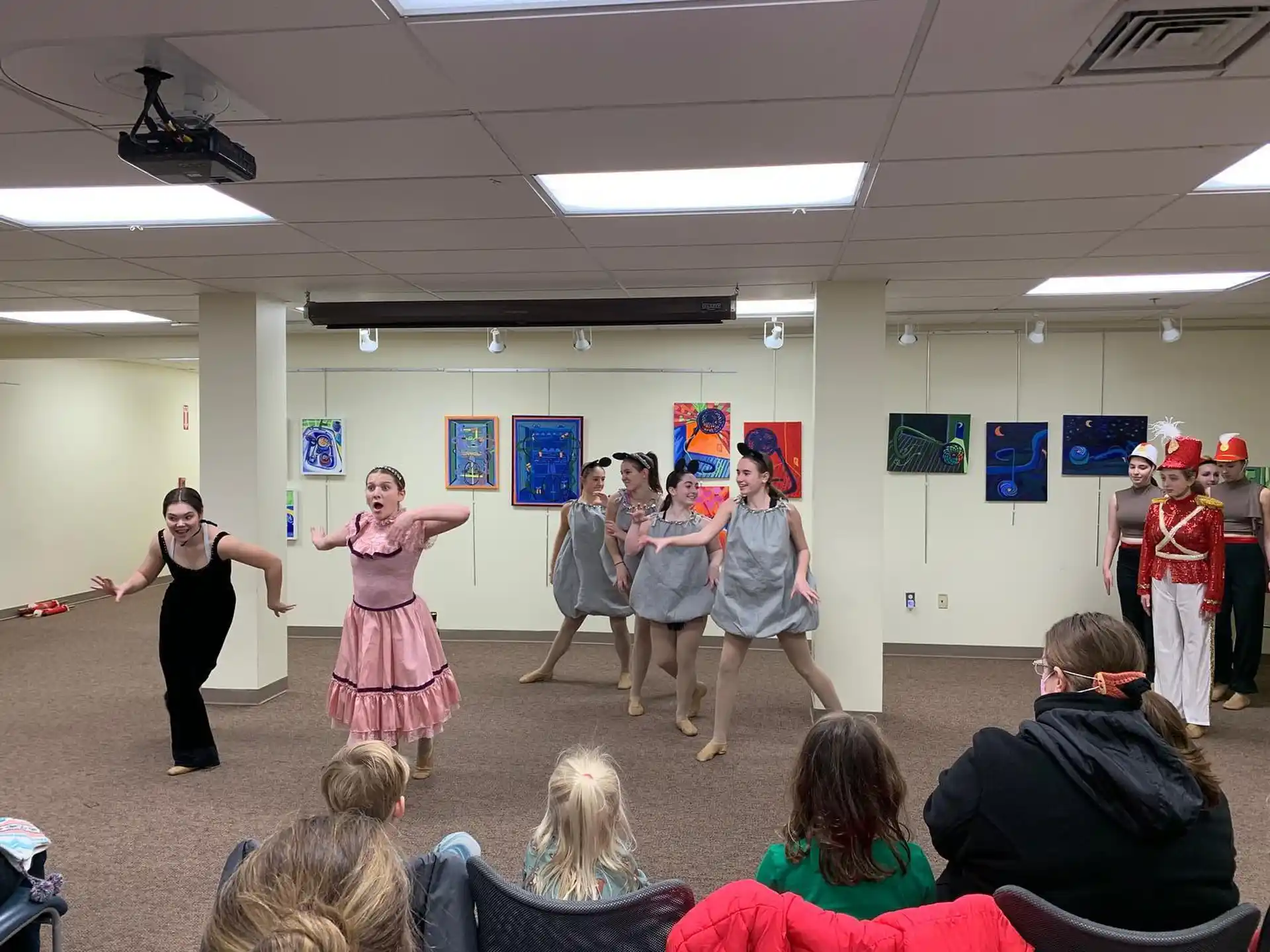 a group of people dancing in a room with a crowd watching