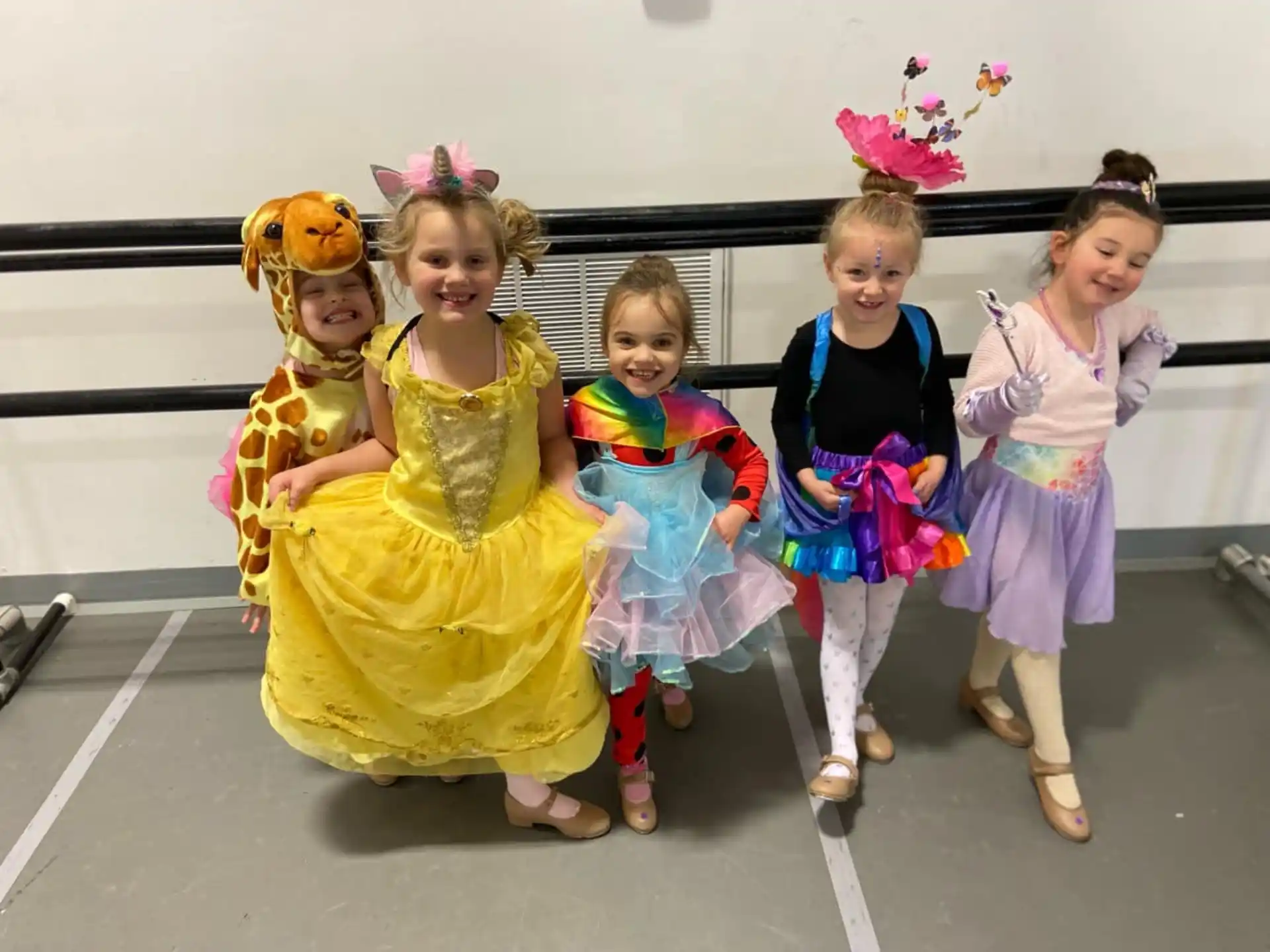 a group of girls in dresses and dresses posing for a photo