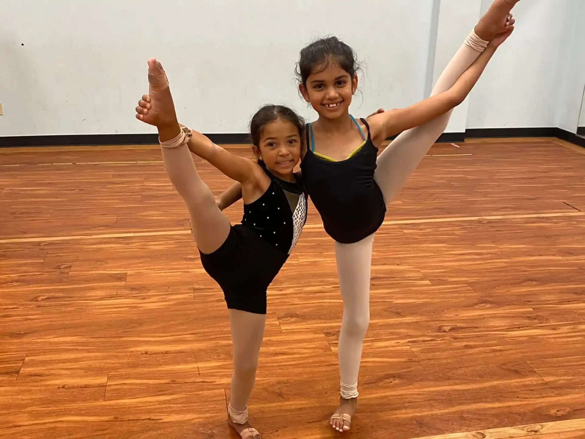 two women dancing on a wood floor