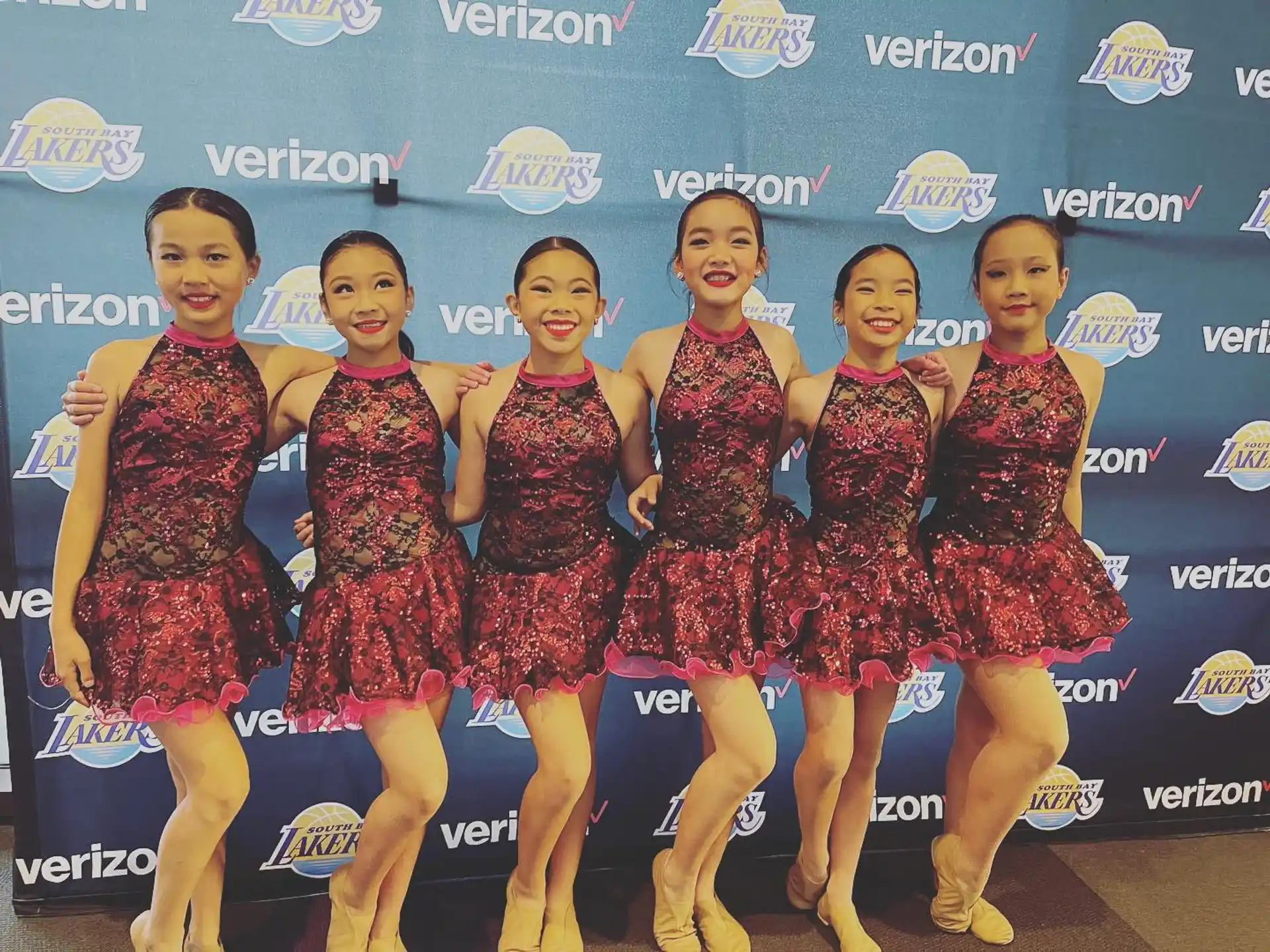 a group of women in red and black dresses posing for a photo