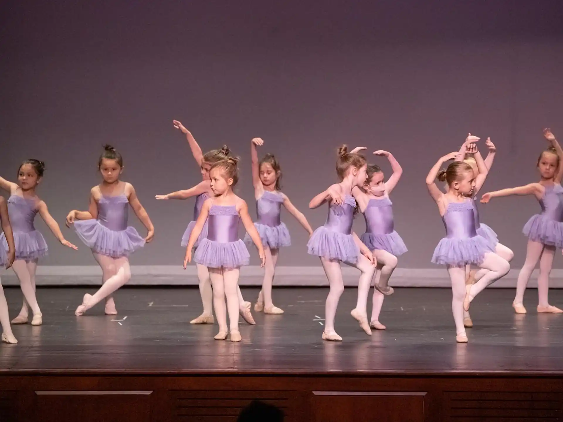a group of girls in blue dresses on a stage