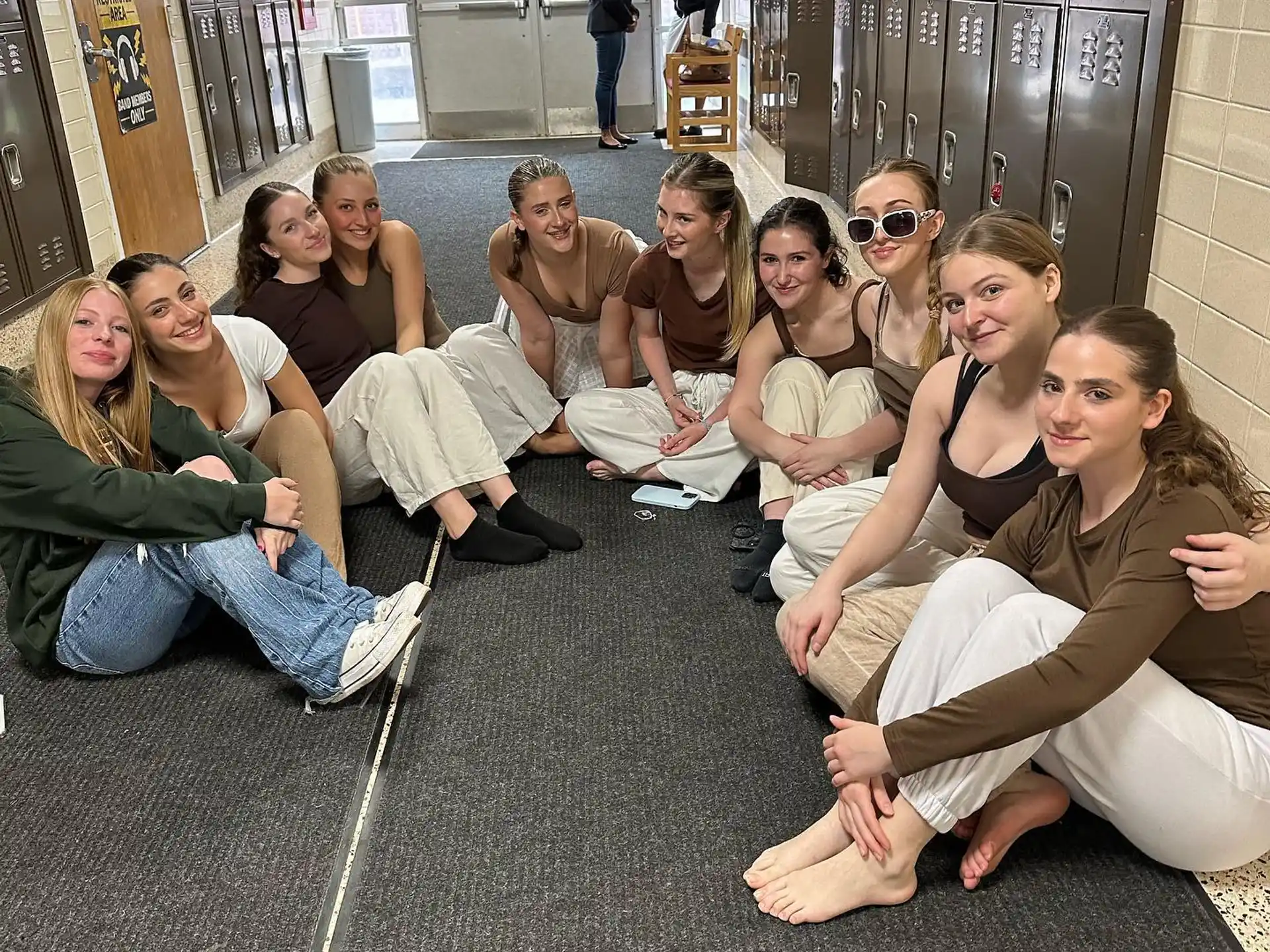 a group of people sitting on the floor posing for the camera