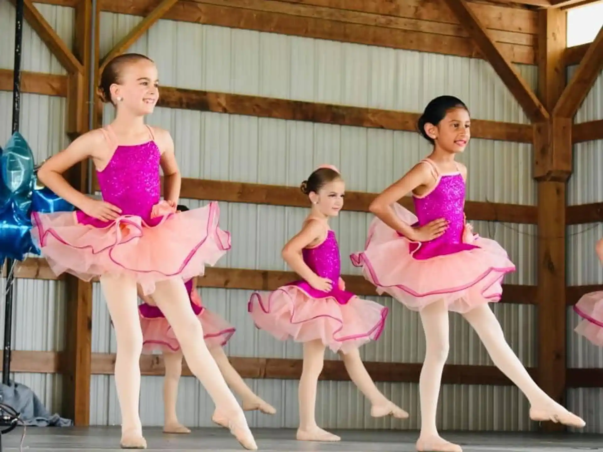 a group of girls in pink dresses on a trampoline