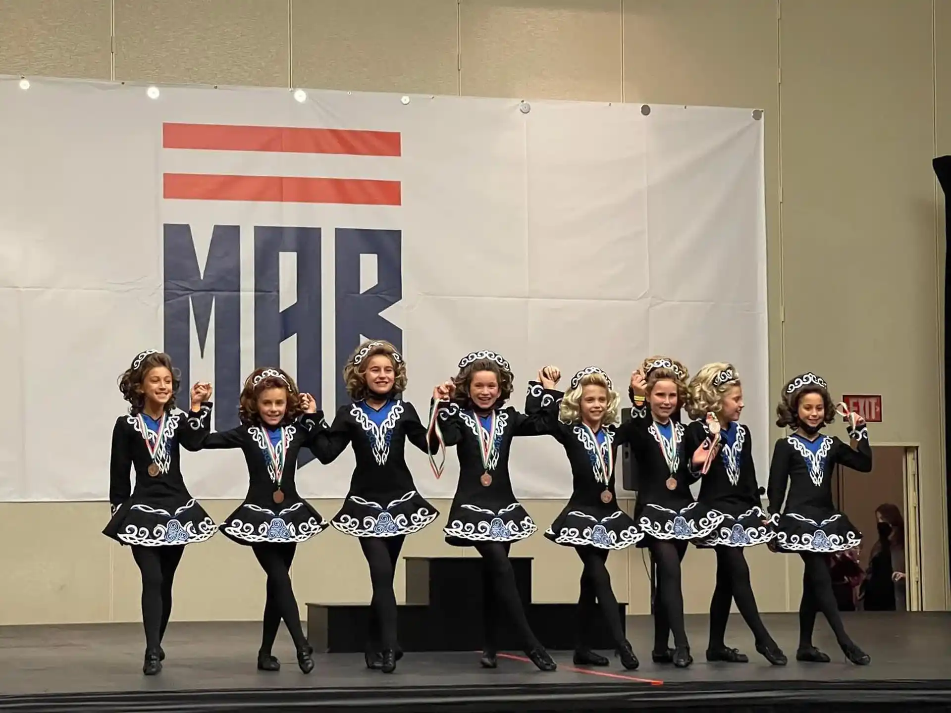 a group of women in black and white uniforms on a stage